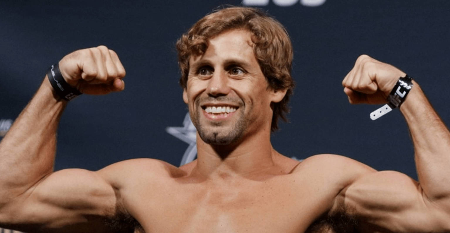 MMA 桌布 壁紙 — 一個赤膊、捲髮的肌肉男，在深藍色背景下，雙臂彎曲，露出燦爛的笑容。
