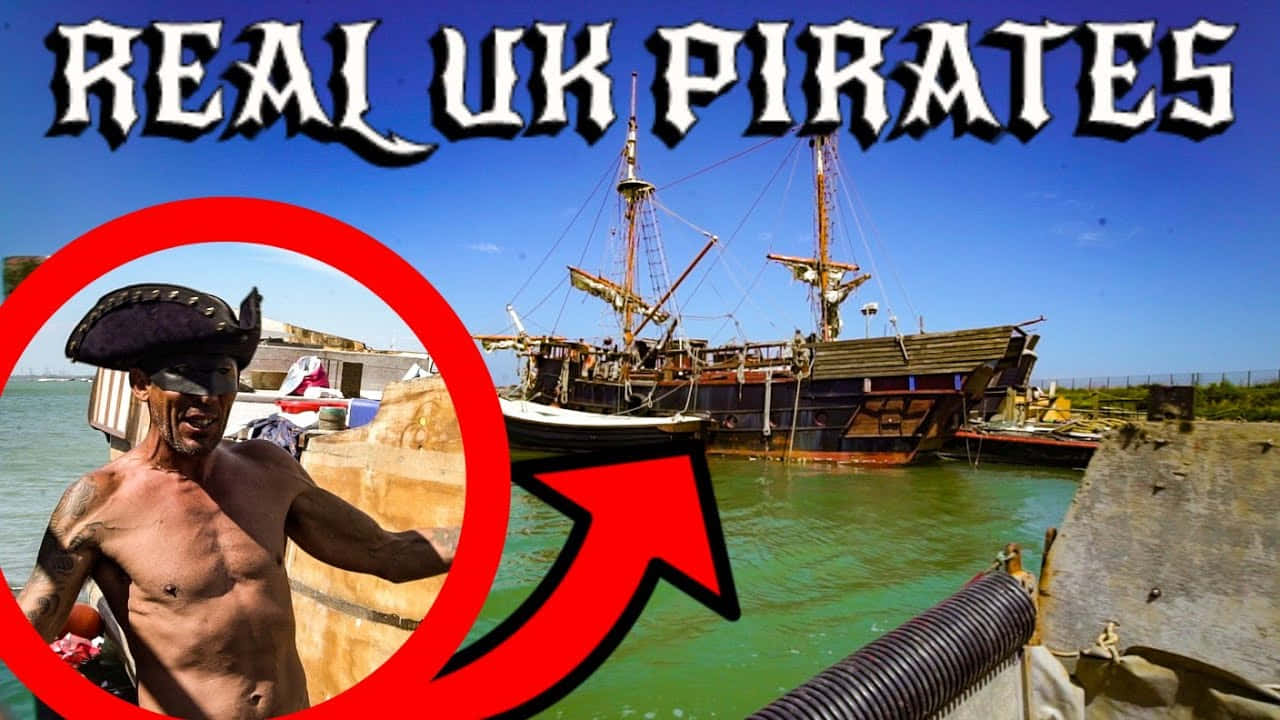 Real Pirate 桌布 壁紙 — 一個赤膊戴海盜帽的男人指向一艘停泊在渾濁綠色海水中的大型木船，天空湛藍。