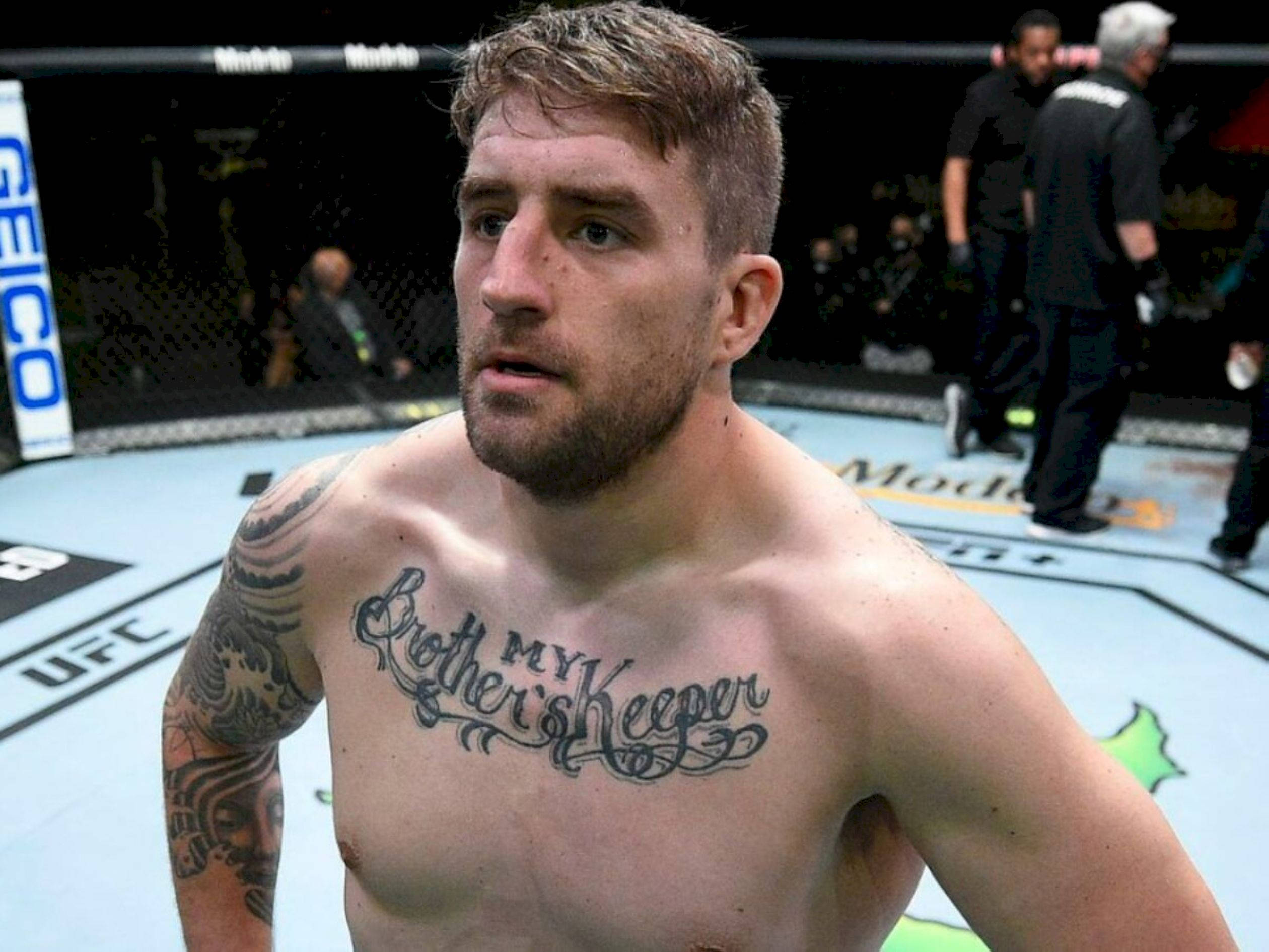 UFC 桌布 壁紙 — 一個赤裸上身的戰士，帶有「My Brother's Keeper」刺青，在UFC八角籠內凝視著。