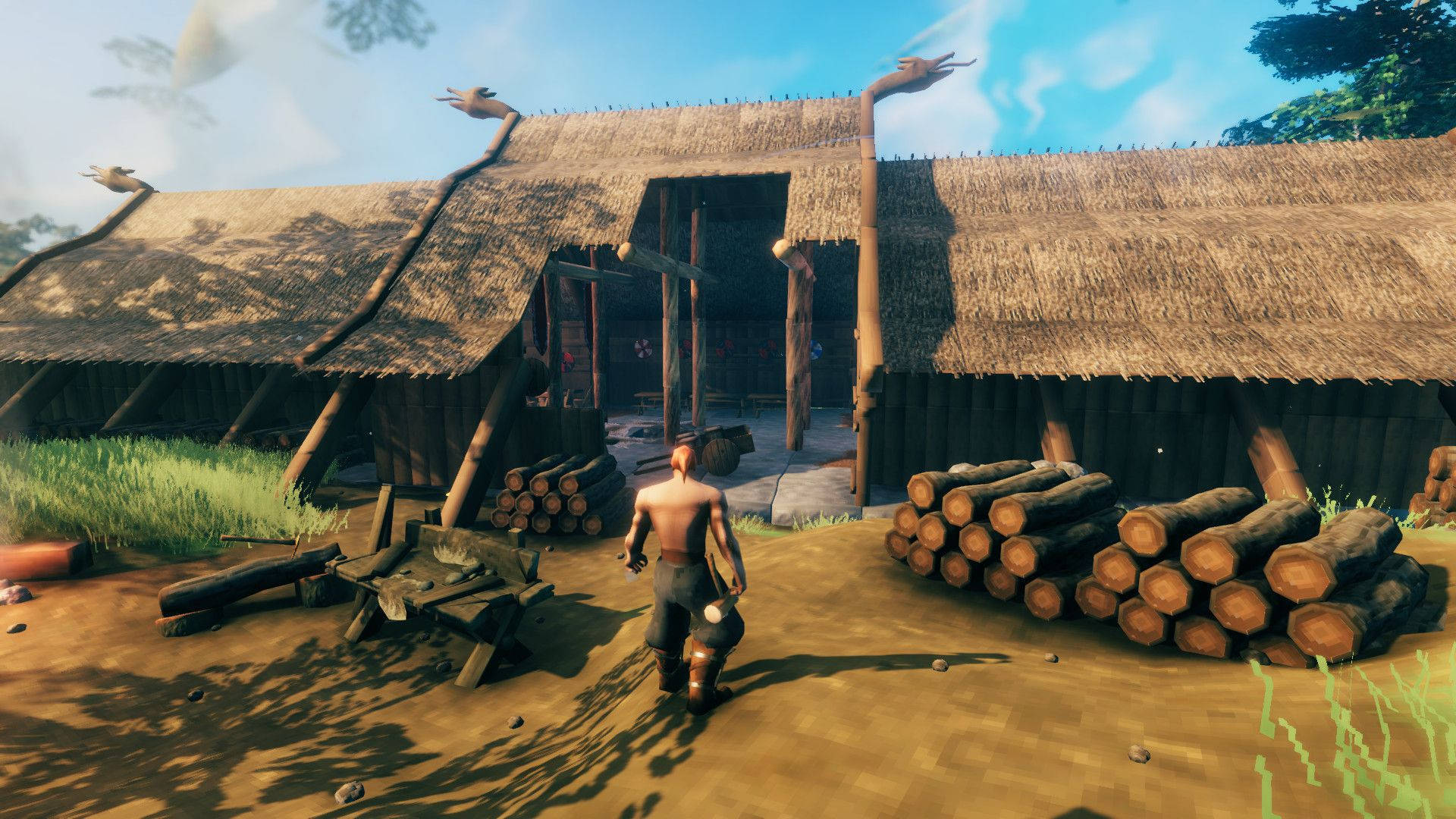 Valheim 桌布 壁紙 — 一個赤裸上身的戰士在明亮的日光下走向一間茅草屋頂和堆疊木頭的質樸木屋。