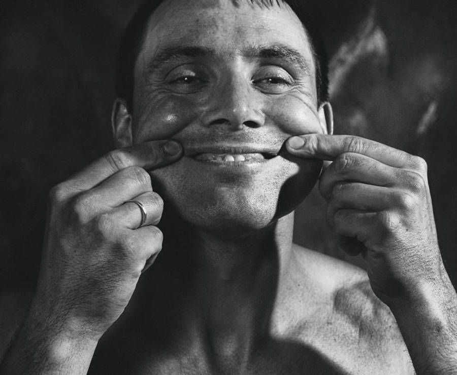 Fake Smile 桌布 壁紙 — 一個赤裸上身的男人在黑白肖像中，用雙手頑皮地將臉頰向外拉。