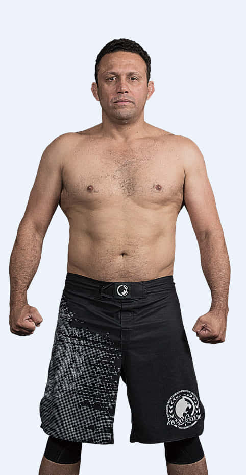 martial arts 桌布 壁紙 — 一個赤裸上身的男性戰士穿著黑色短褲，握緊拳頭站在純色淺色背景前。