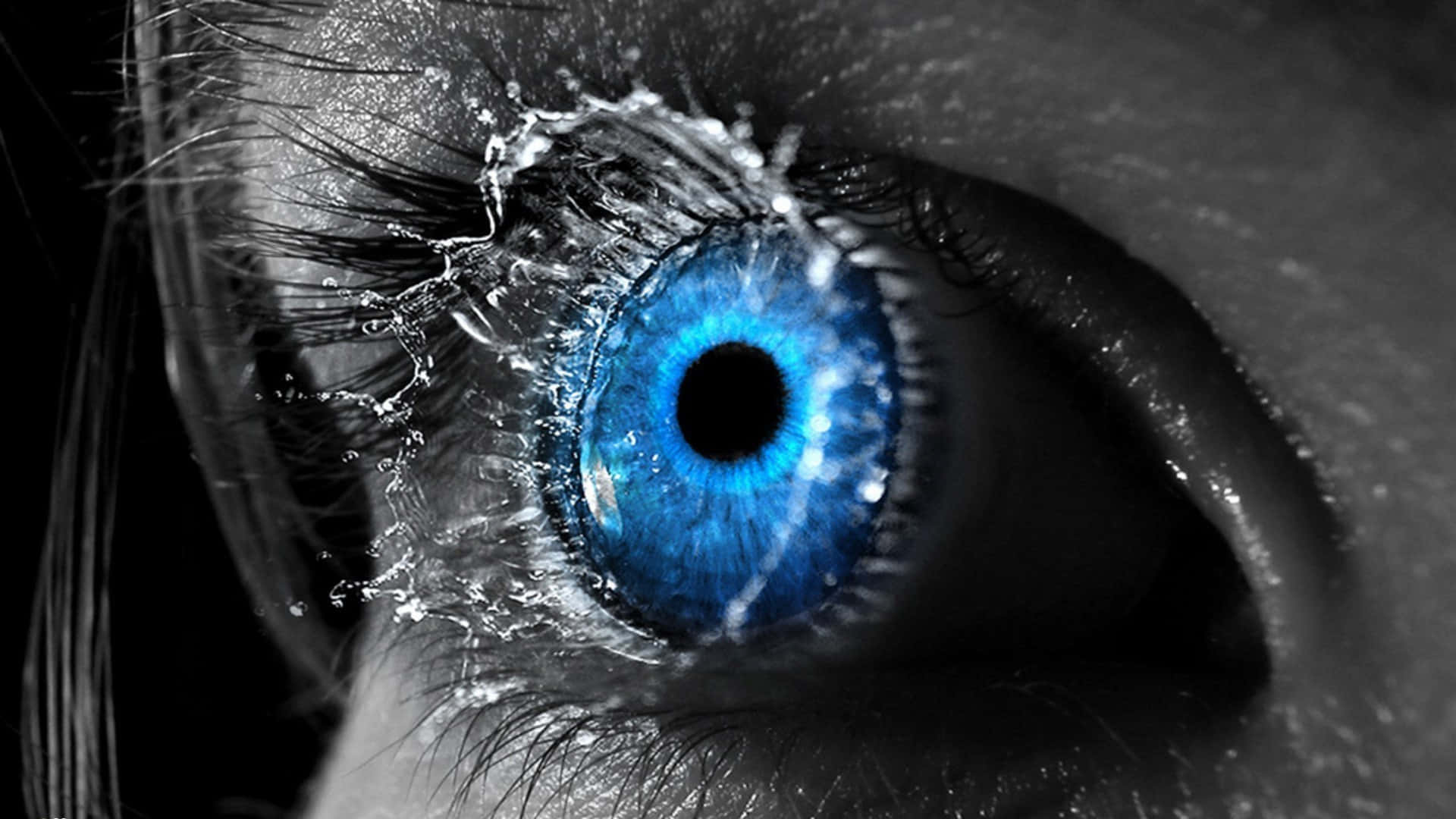 Eyeball 桌布 壁紙 — 一個超現實的特寫，一隻鮮豔的藍色眼睛，表面有水珠飛濺，背景為黑白。