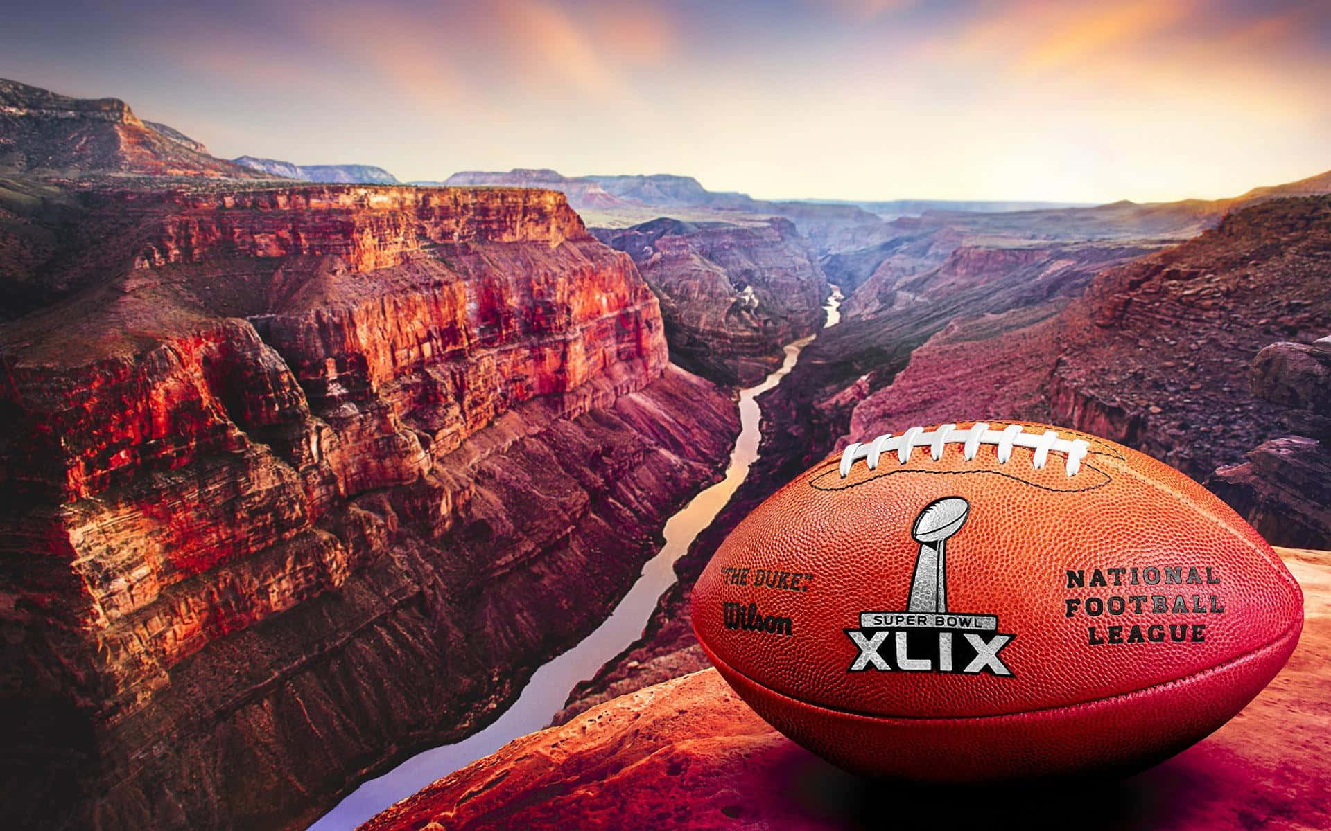 Super Bowl 桌布 壁紙 — 一個超級碗XLIX美式足球在日落時分擱在峽谷邊緣，下方有蜿蜒的河流。