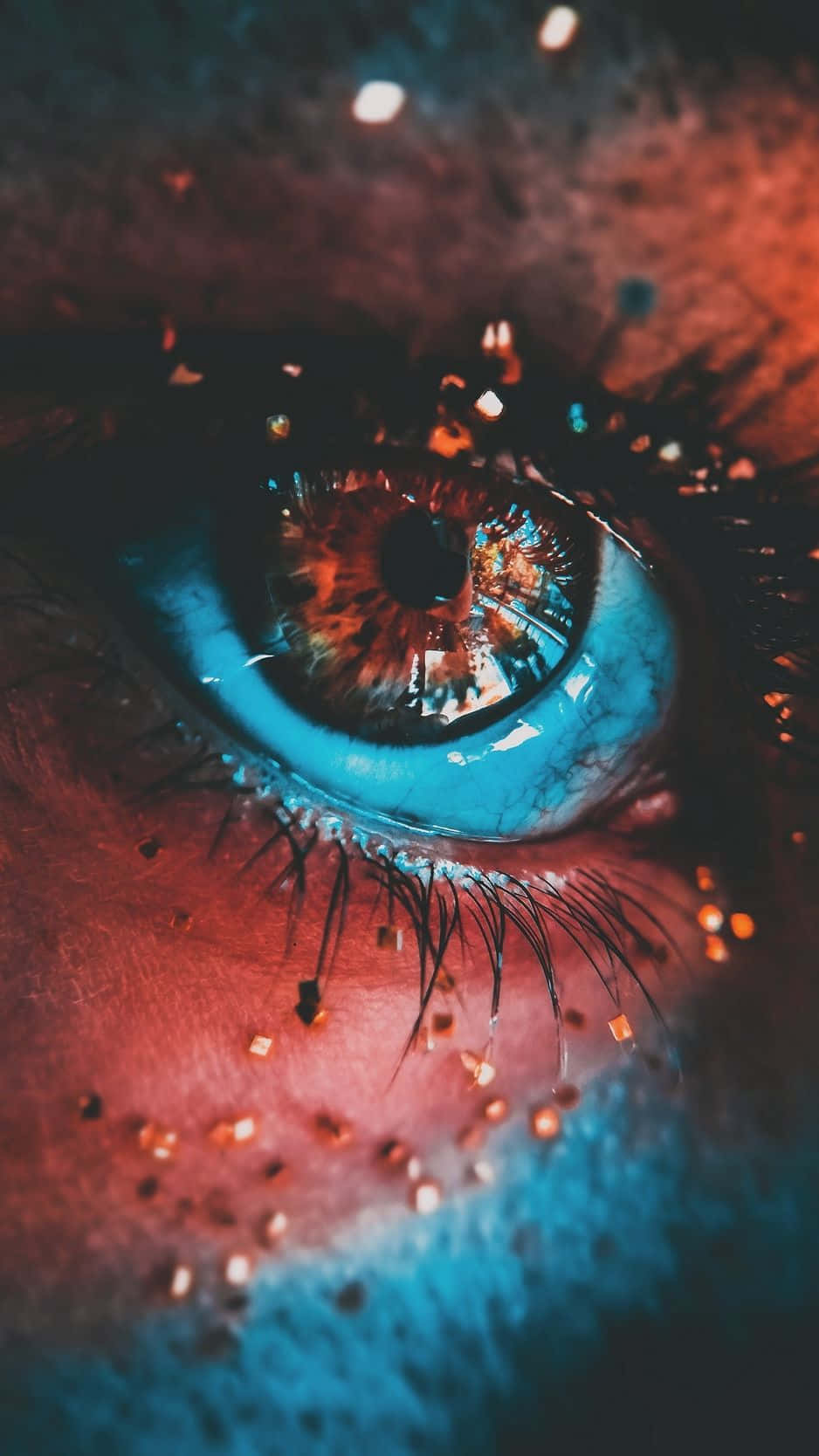 Evil Eye 桌布 壁紙 — 一個超詳細的人類眼睛特寫，擁有生動的藍色虹膜和火熱的橙色反射，周圍環繞著發光粒子。