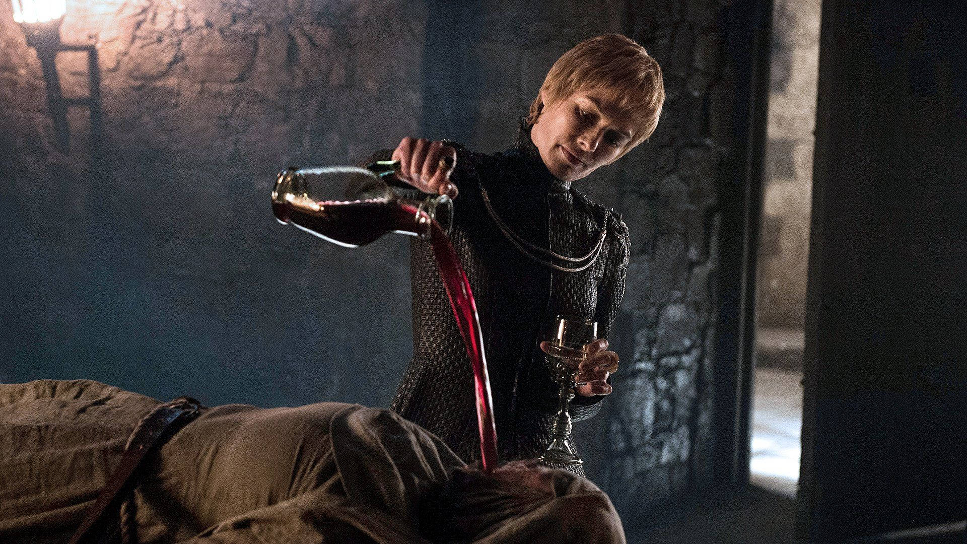 cersei lannister 桌布 壁紙 — 一個身穿暗色盔甲的女人在昏暗的石室中，將玻璃瓶中的紅色液體倒入高腳杯，澆在一個俯臥的人形上。