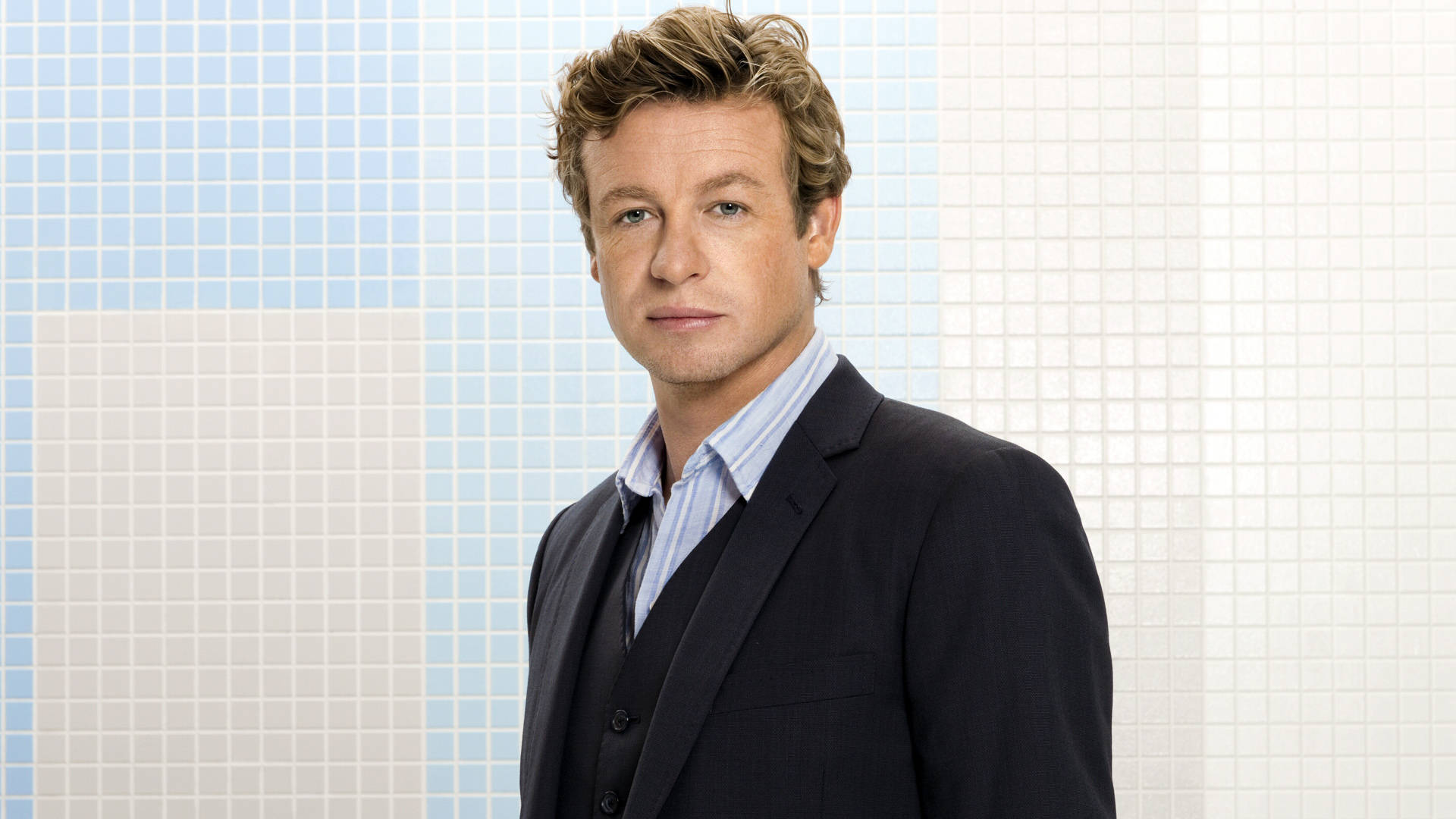Celebrity 桌布 壁紙 — 一個身穿深色西裝和條紋襯衫的男人自信地站在藍白瓷磚牆前。