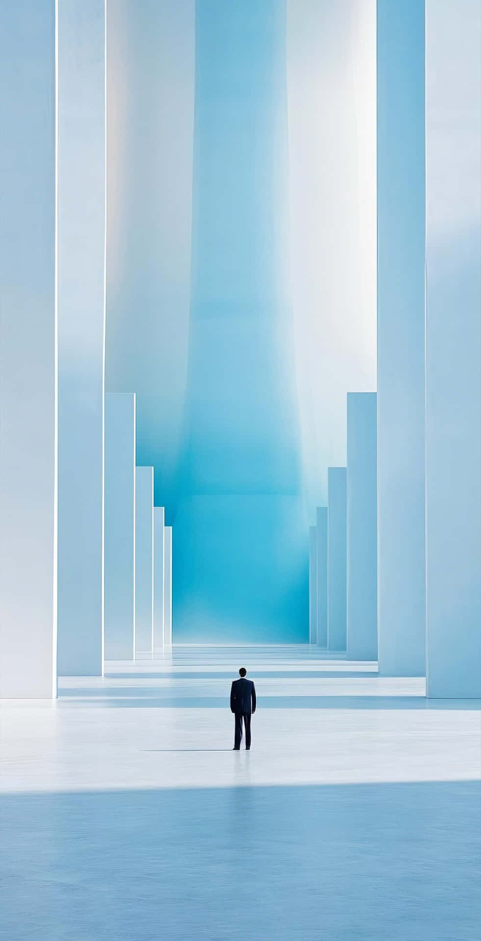 solitary figure before abstract pastel structure 壁紙 — 一個身穿深色西裝的孤獨男子，站在沐浴在柔和藍光中的高聳白色柱子的底部。