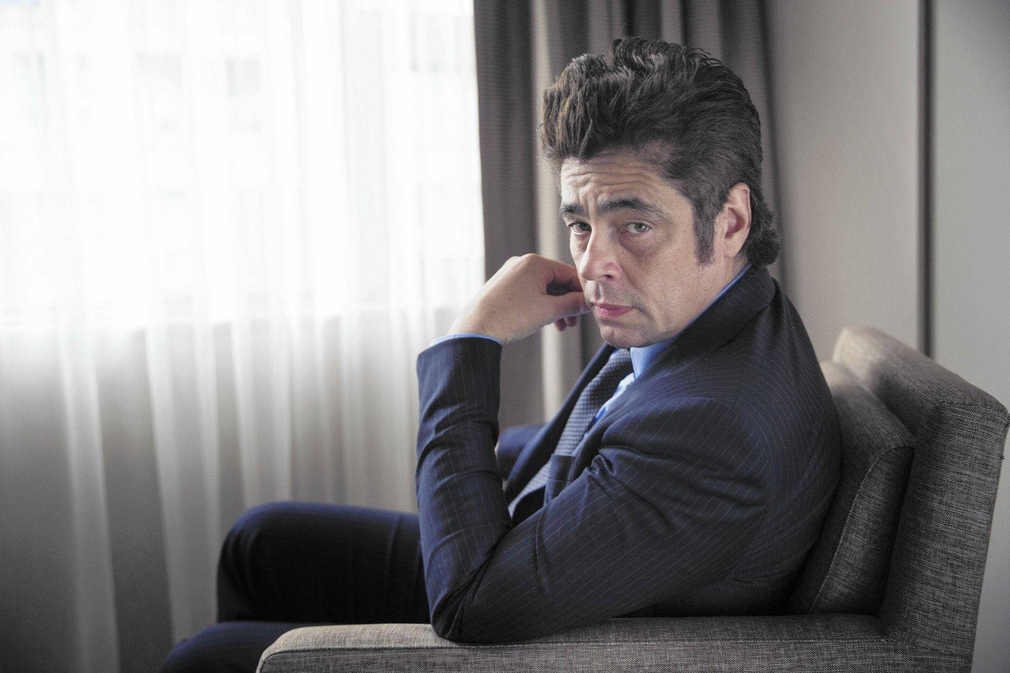 Celebrity 桌布 壁紙 — 一個身穿深色西裝的男人，坐在明亮的窗邊灰色扶手椅上，窗簾輕薄，若有所思。