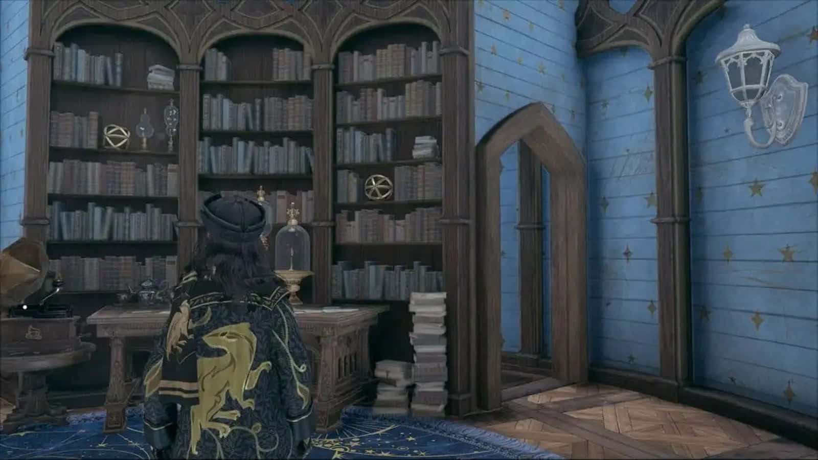 The Hogwarts Headmaster's Office 桌布 壁紙 — 一個身穿獅子徽章斗篷的角色站在一個宏偉的藍色圖書館中，圖書館有高聳的書架和星形圖案的牆壁。