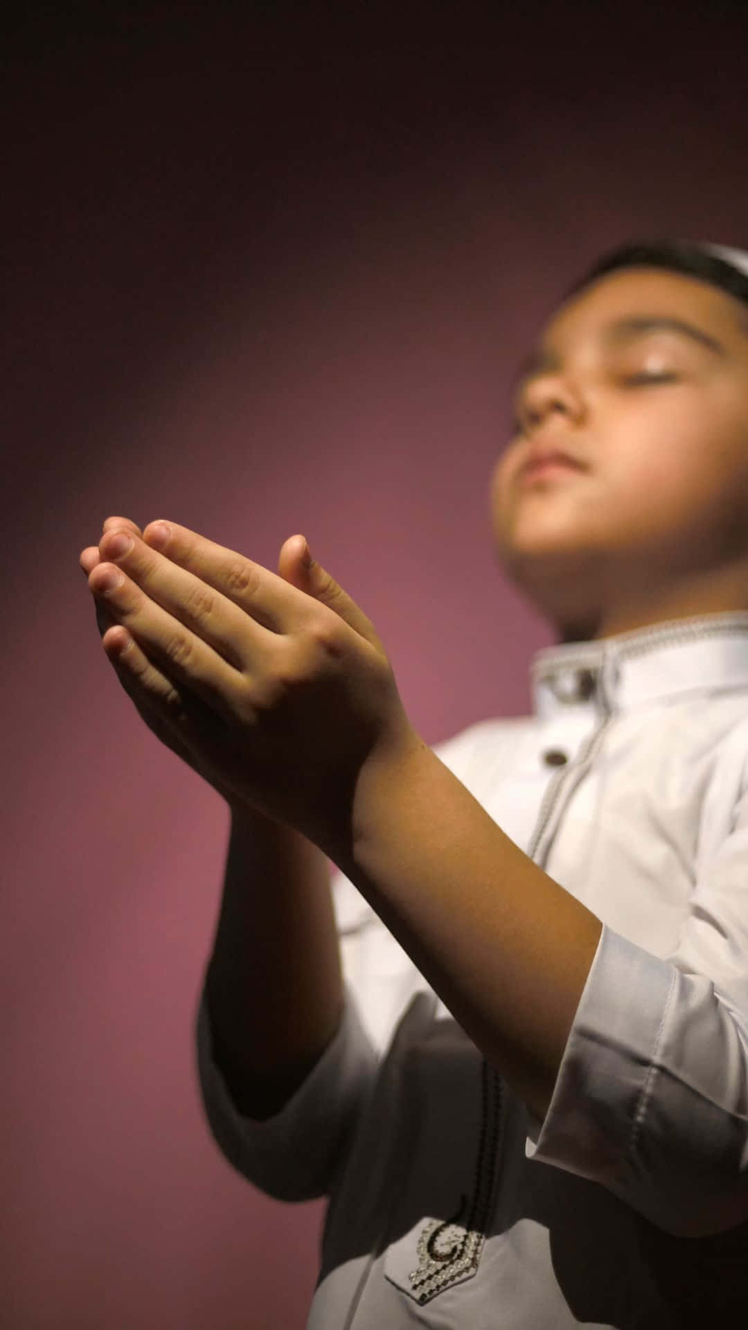 Praying 桌布 壁紙 — 一個身穿白色祈禱服的小男孩，在柔和的紫色背景下虔誠地合十雙手。