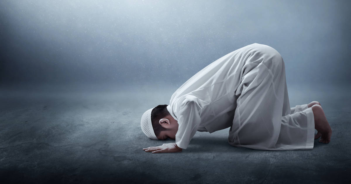 Praying 桌布 壁紙 — 一個身穿白色祈禱服的小男孩跪在黑暗的地板上，在霧氣瀰漫的攝影棚中，頭低垂在柔和的聚光燈下。
