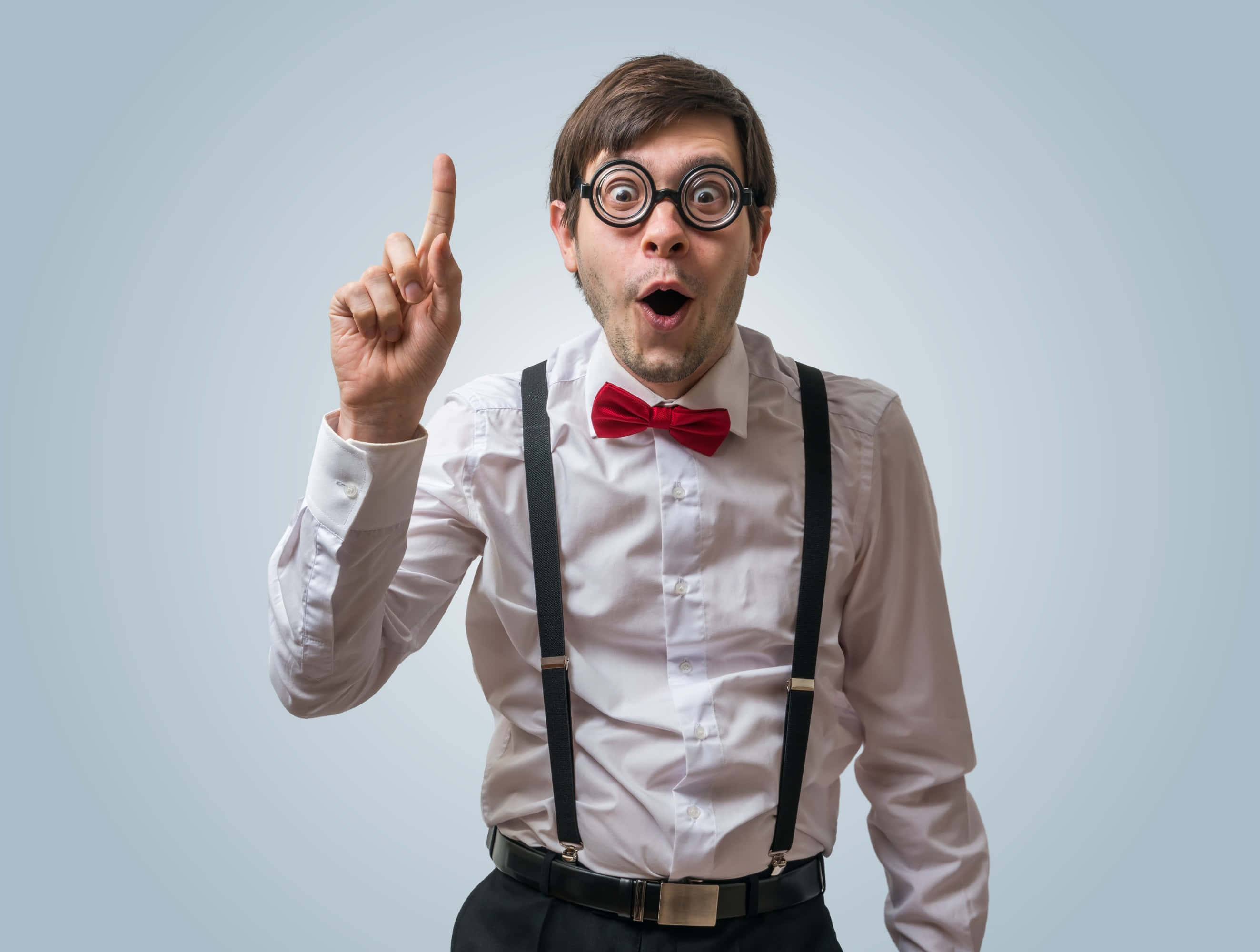 Nerd 桌布 壁紙 — 一個身穿白襯衫、紅色領結和吊帶的男人，睜大眼睛、張開嘴巴，驚訝地向上指。