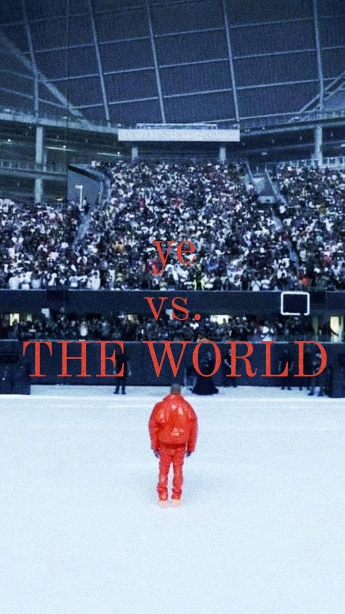 Kanye West Album Cover 桌布 壁紙 — 一個身穿紅色西裝的孤獨身影站在廣闊競技場的舞台中央，面對著高天花板下的一片觀眾海。