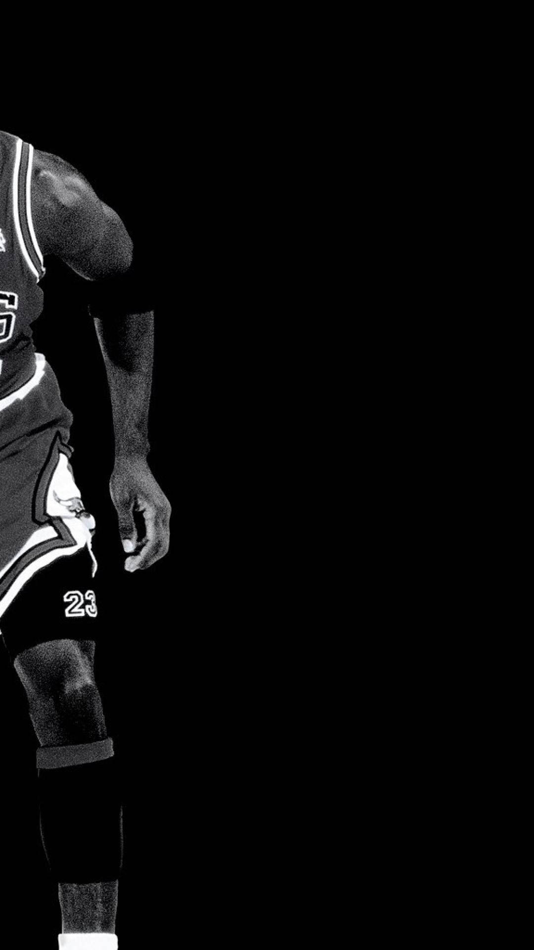 籃球 Jordan 桌布 壁紙 — 一個身穿芝加哥公牛隊23號球衣的籃球運動員的黑白剪影，背景為純黑色。