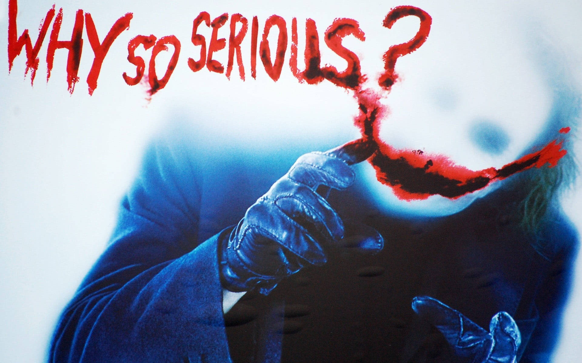 Why So Serious Joker 桌布 壁紙 — 一個身穿藍色西裝和手套的威脅性人物在臉上畫出血淋淋的笑容，而上方「為什麼這麼嚴肅？」的文字以紅色滴落。