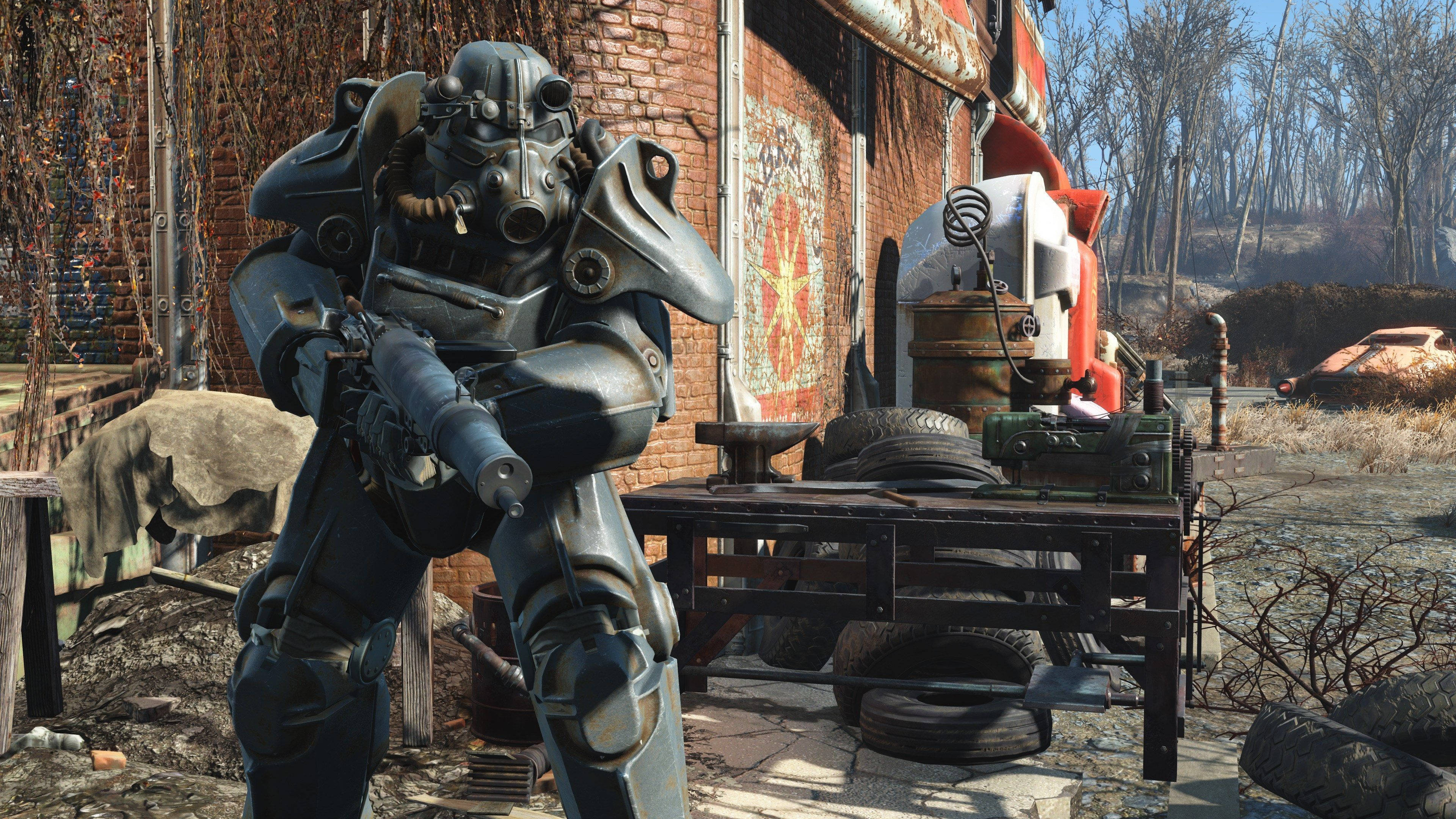 Fallout 4 桌布 壁紙 — 一個身穿重裝甲的廢土倖存者，在破敗的後末日廢品場中，拿著步槍在雜亂的工作檯旁站崗。