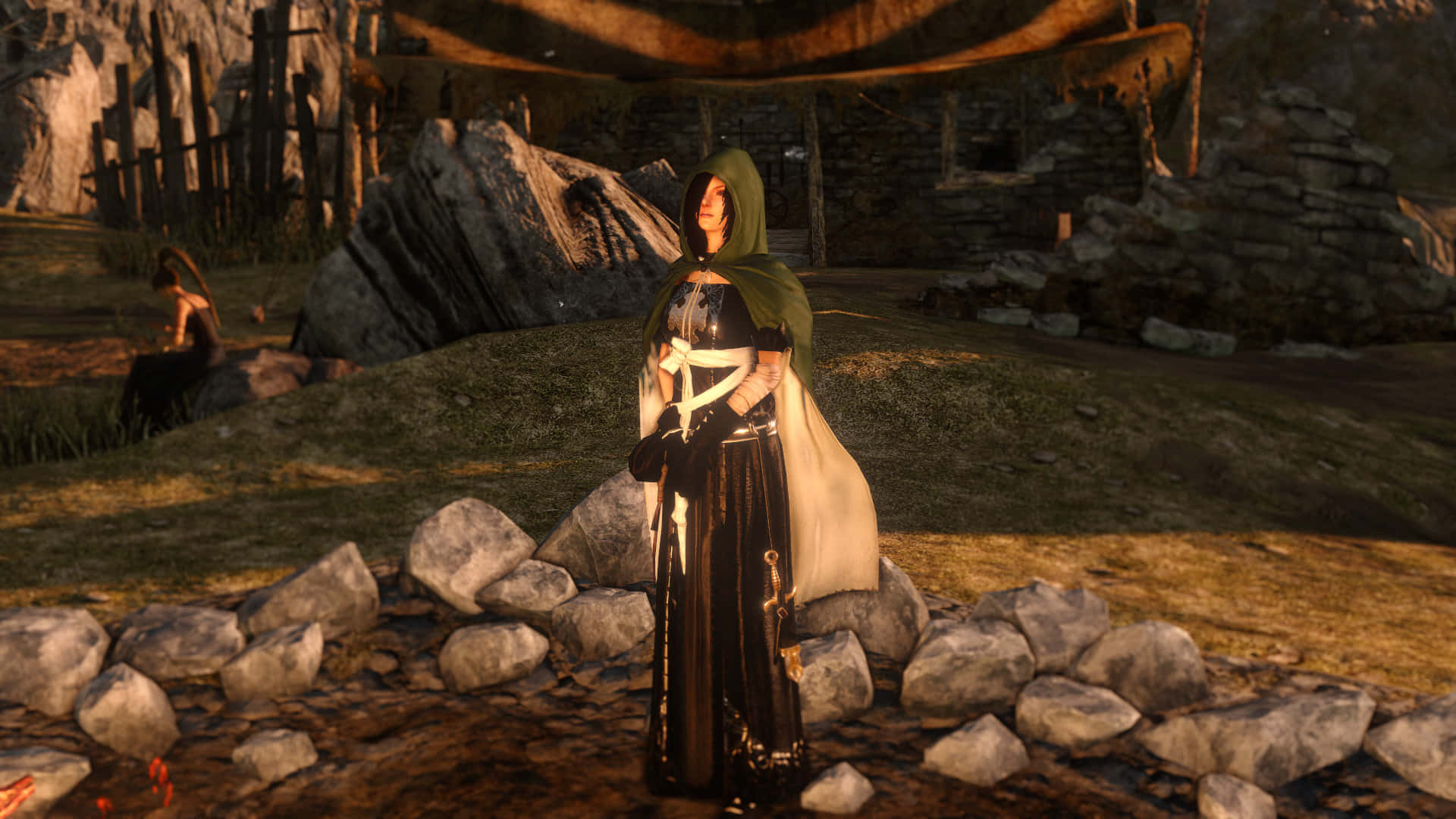 Dark Souls Emerald Herald 桌布 壁紙 — 一個身穿黑色和綠色長袍的戴帽人物，在黃金時段莊嚴地站在一個質樸的石村中的岩石之間。