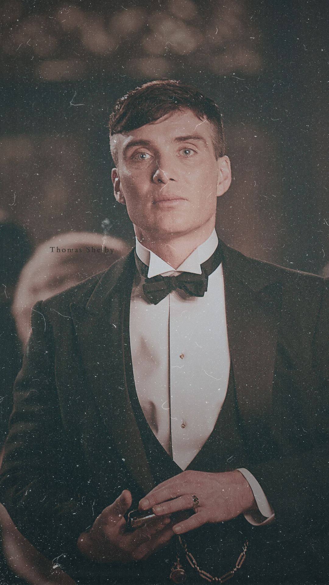 穿著正式黑色燕尾服的男人，表情嚴肅地拿著煙。 — Peaky Blinders 壁紙