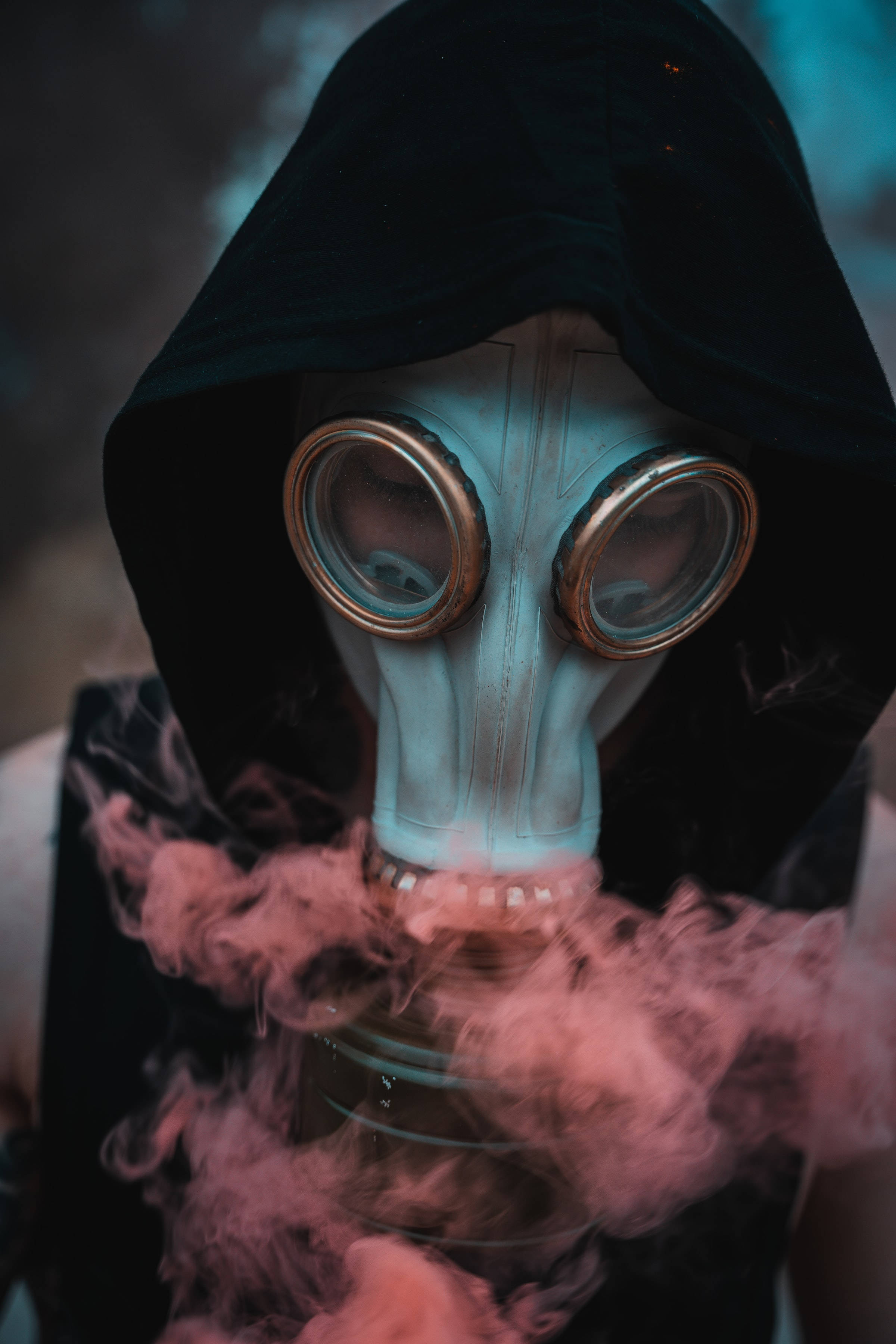 Mask 桌布 壁紙 — 一個身穿黑色連帽衫的人呼出粉紅色煙霧，同時戴著一個帶有黃銅邊框鏡片的復古風格防毒面具。