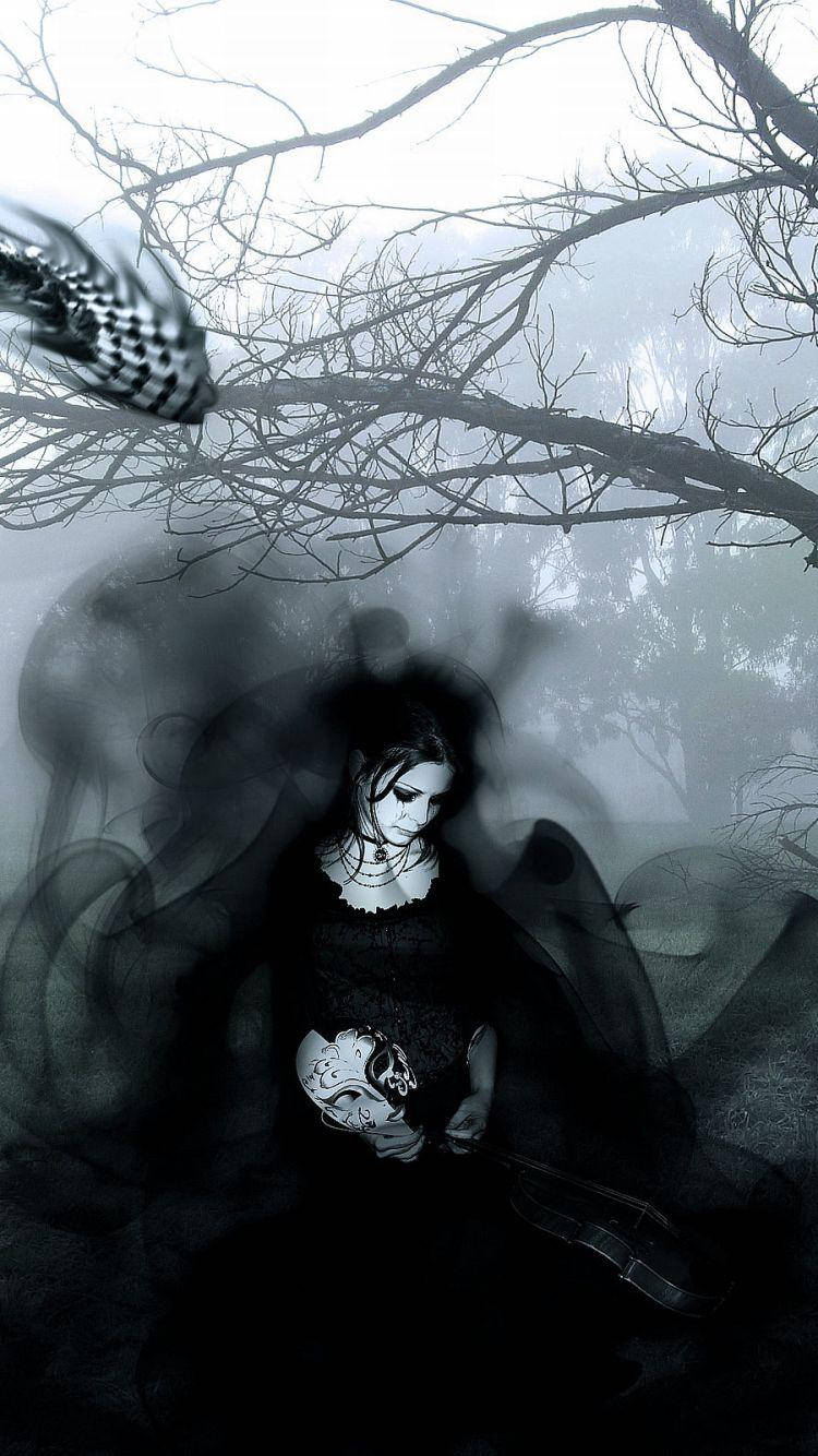 Gothic Phone 桌布 壁紙 — 一個身穿黑衣的幽靈女子在光禿禿的樹枝下，於旋轉的迷霧中手持一個頭骨，構成一個令人不安的黑白場景。