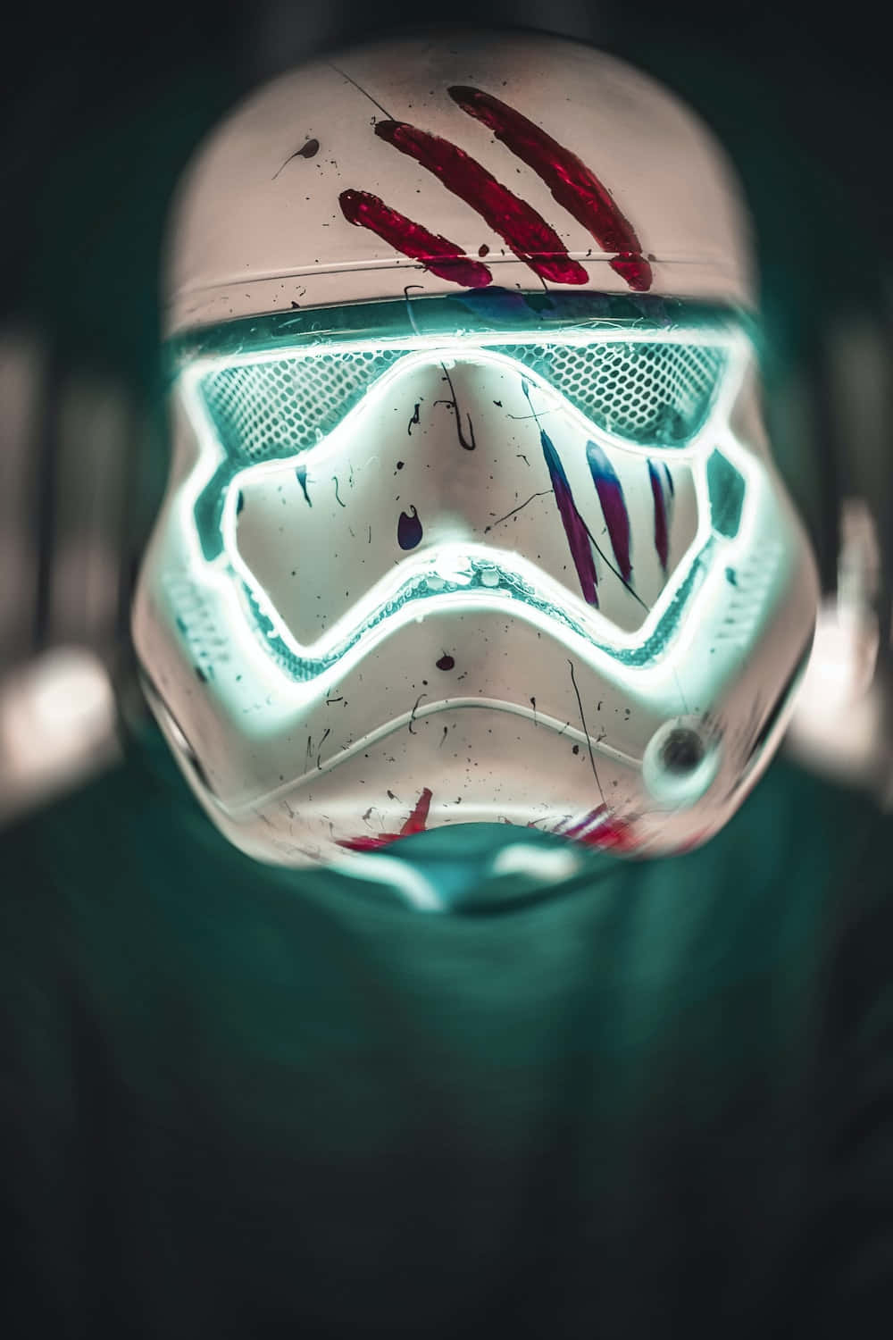 Star Wars Profile 桌布 壁紙 — 一個近距離特寫，展示一個佈滿戰鬥痕跡的風暴兵頭盔，帶有發光的青綠色面罩和紅色爪痕，背景為深色。