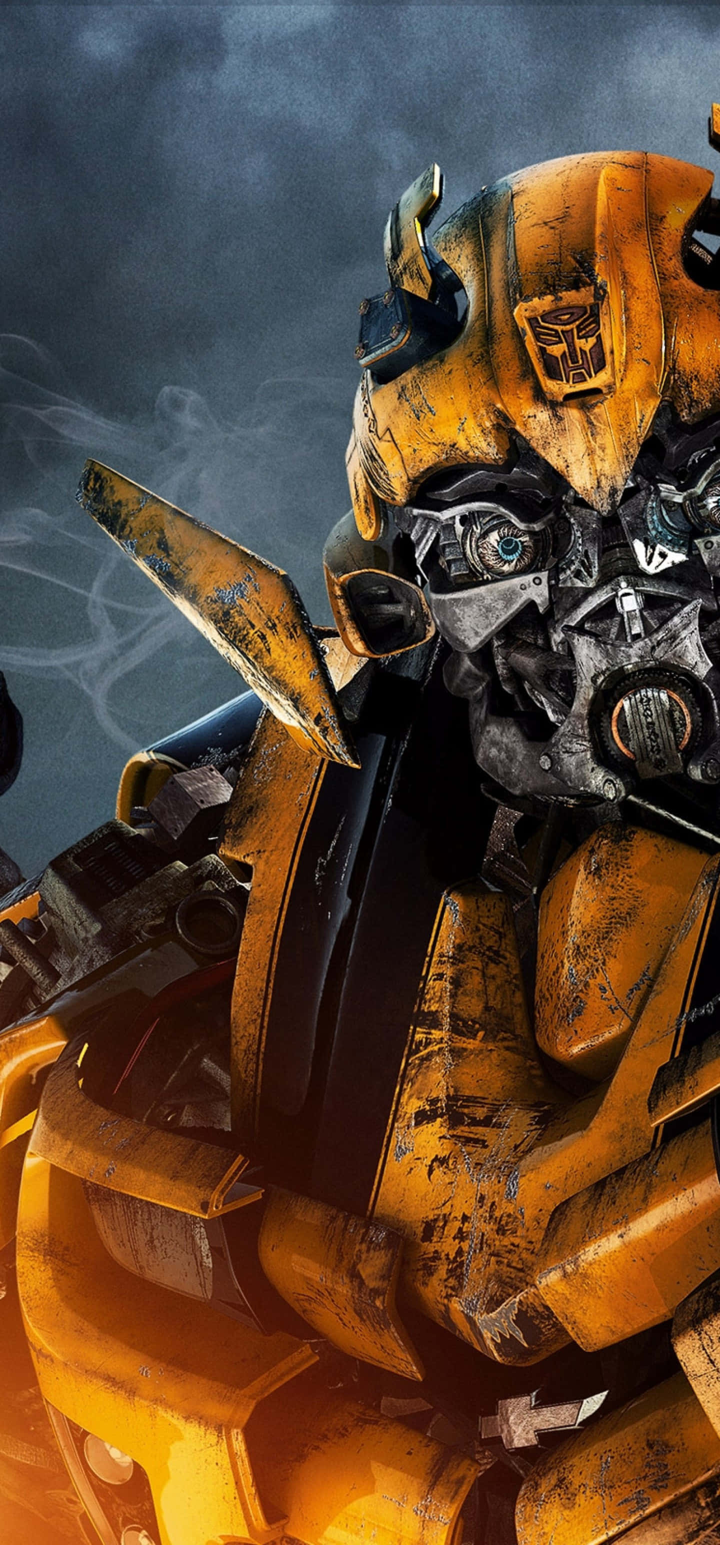 Bumblebee Transformer 桌布 壁紙 — 一個近距離特寫，展示一個因戰鬥而破損的黃色機器人，眼睛發光，背後有煙霧升起，背景是黑暗的暴風雨天空。