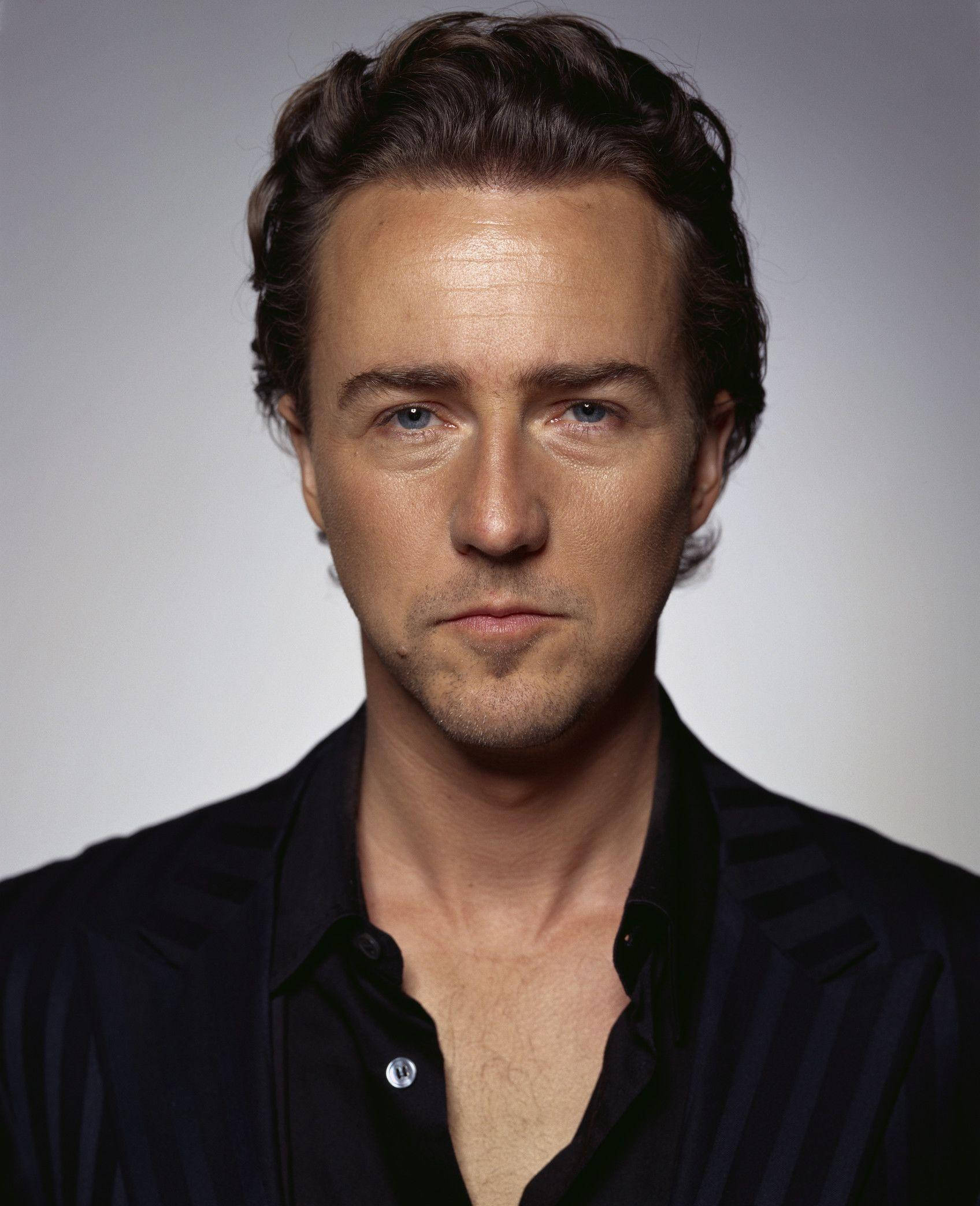 actor 桌布 壁紙 — 一個近距離肖像，一個擁有強烈藍眼睛和深色頭髮的男人，穿著深色條紋襯衫，背景是柔和的灰色。