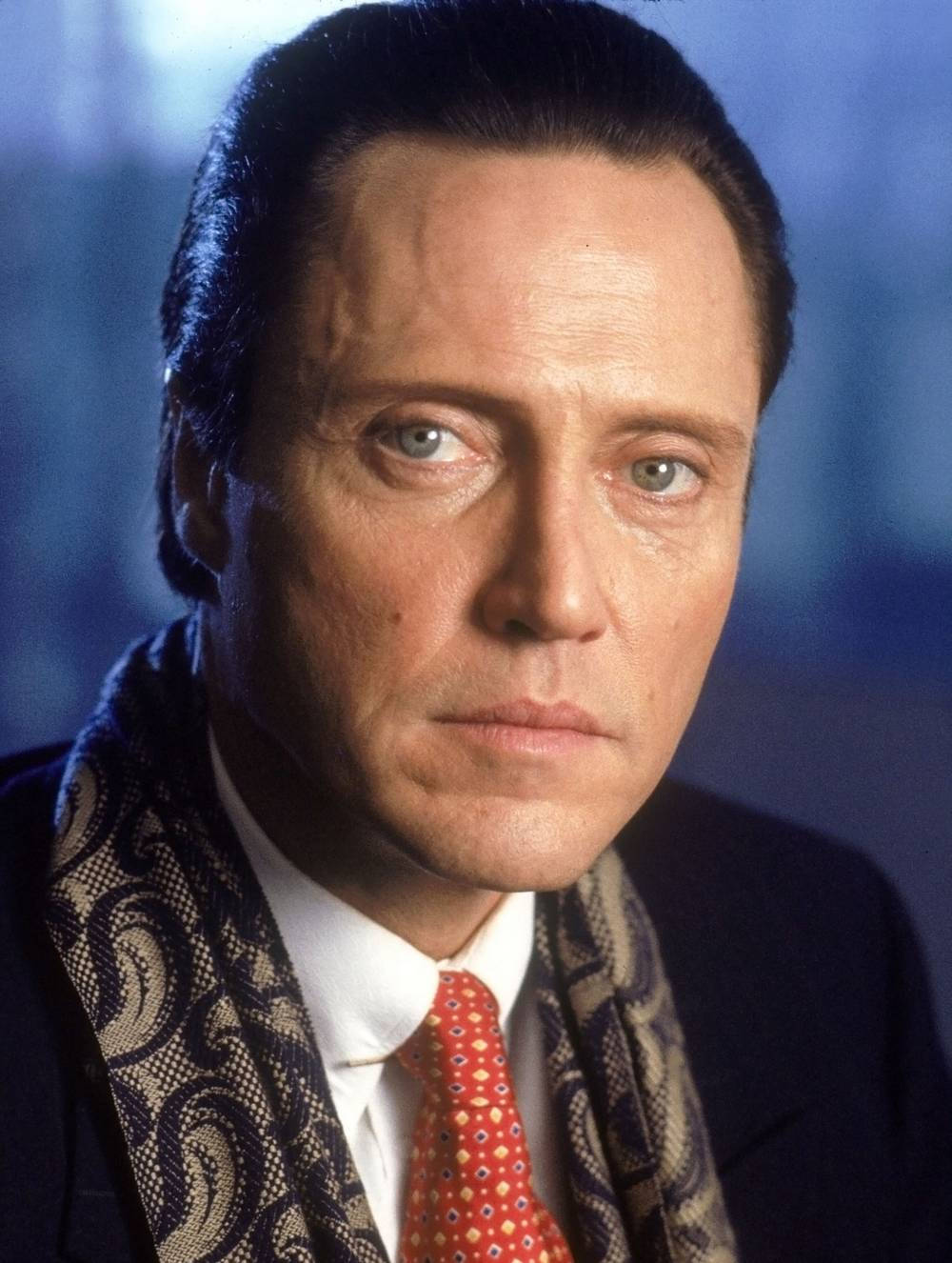 Celebrity 桌布 壁紙 — 一個近距離肖像，一個男人擁有強烈的藍色眼睛，穿著深色西裝、紅色領帶和圖案圍巾，背景是模糊的藍色。