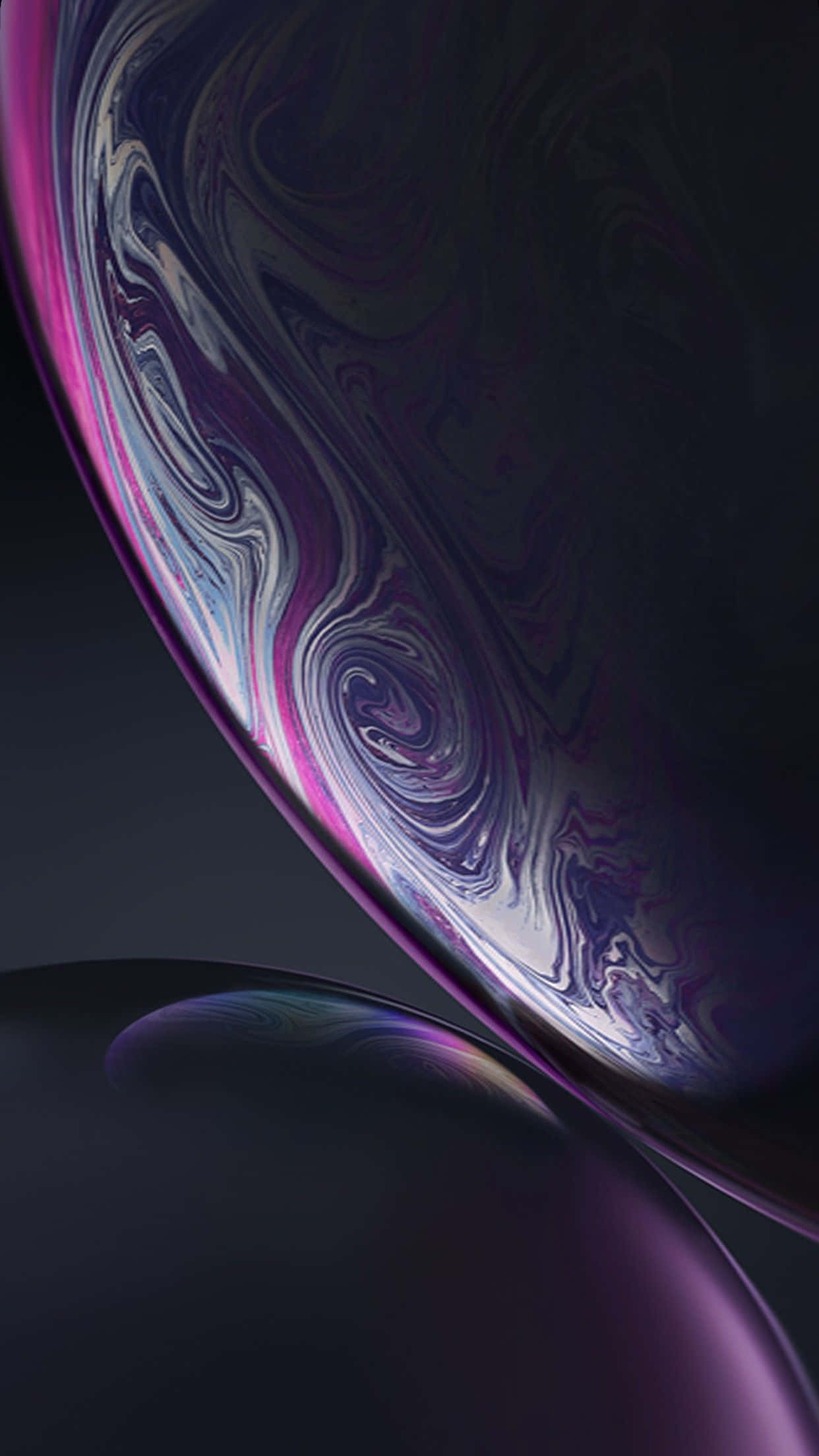 Blue iPhone Xr 桌布 壁紙 — 一個迷人的特寫，呈現深紫色、粉紅色和銀色在黑暗背景中旋轉的虹彩肥皂泡。