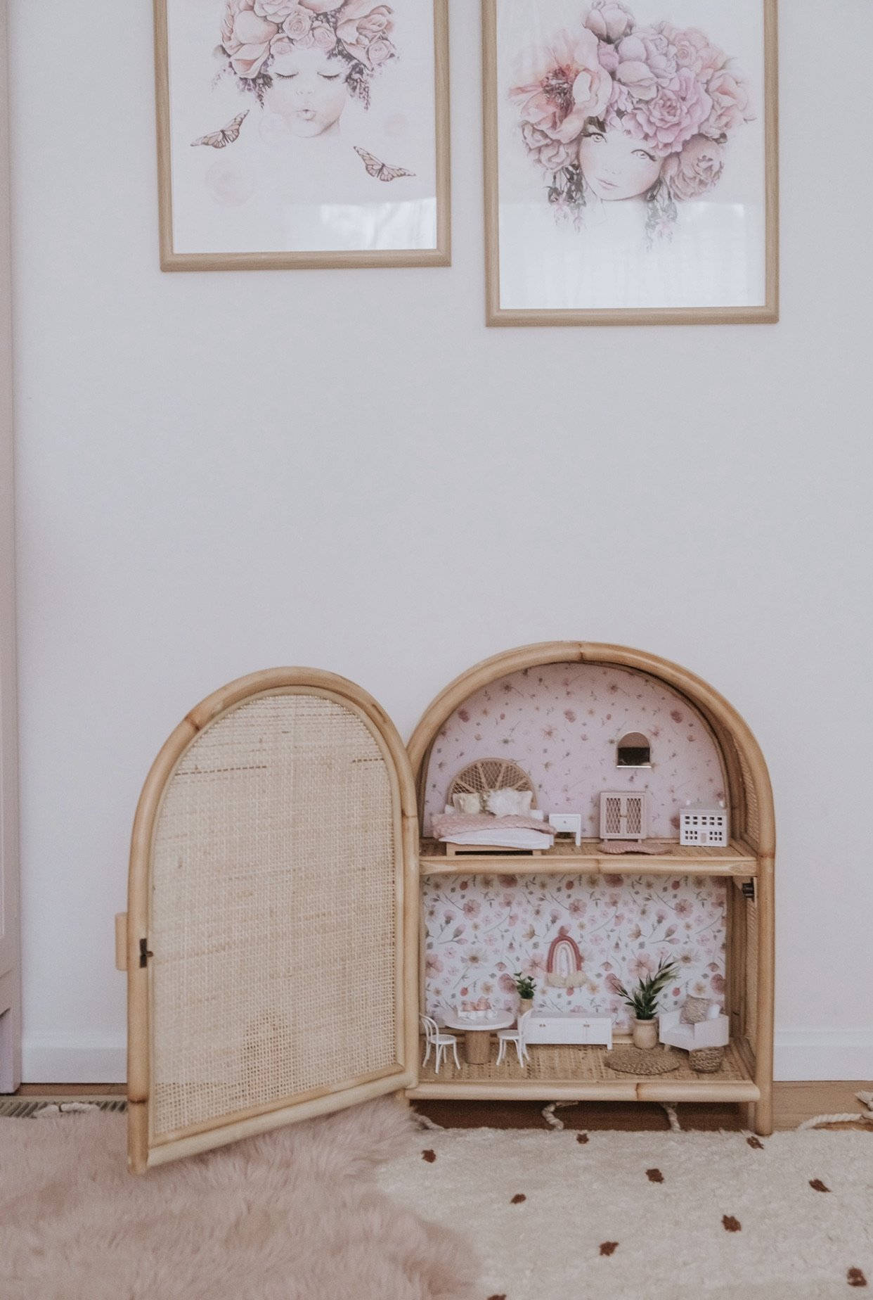 Dollhouse 桌布 壁紙 — 一個迷人的竹製娃娃屋，帶有花卉壁紙和微型家具，打開放在毛絨地毯上，下方是裱框的花卉藝術品。