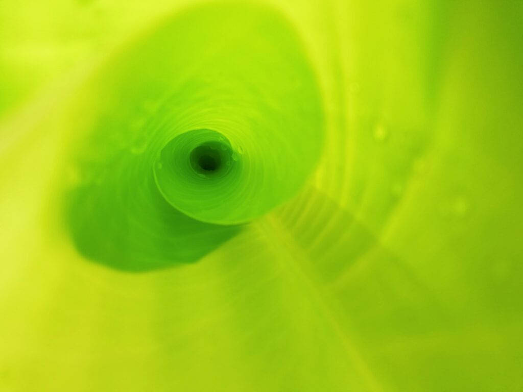 Light Green Plain 桌布 壁紙 — 一個迷人的螺旋隧道，充滿鮮豔的青檸綠色，帶有柔和的漸變和微妙的氣泡，營造出催眠般的抽象效果。