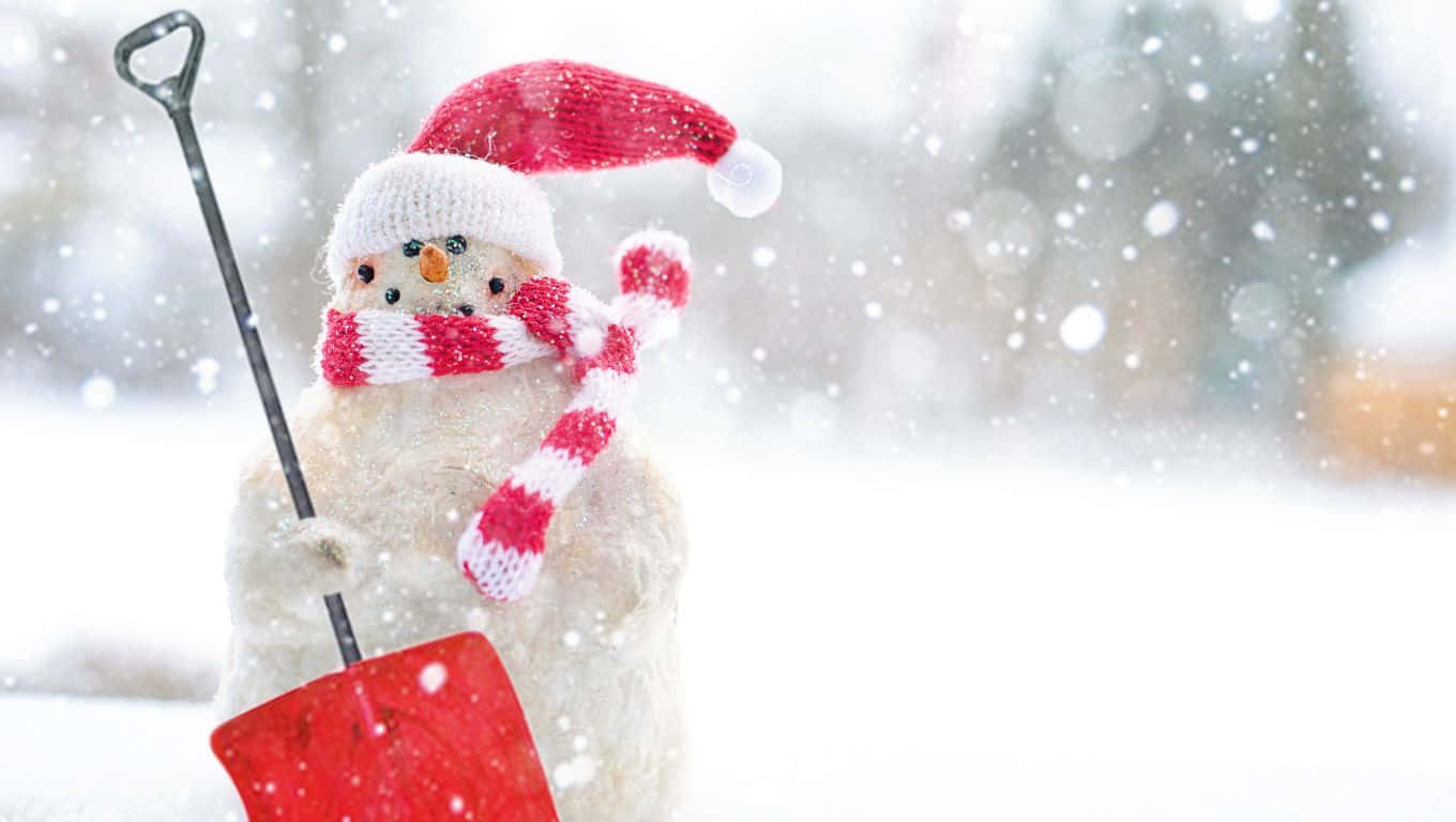 1360x768 桌布 壁紙 — 一個迷人的雪人，戴著紅帽子和條紋圍巾，在雪白的冬日背景下拿著一把紅色的鏟子。