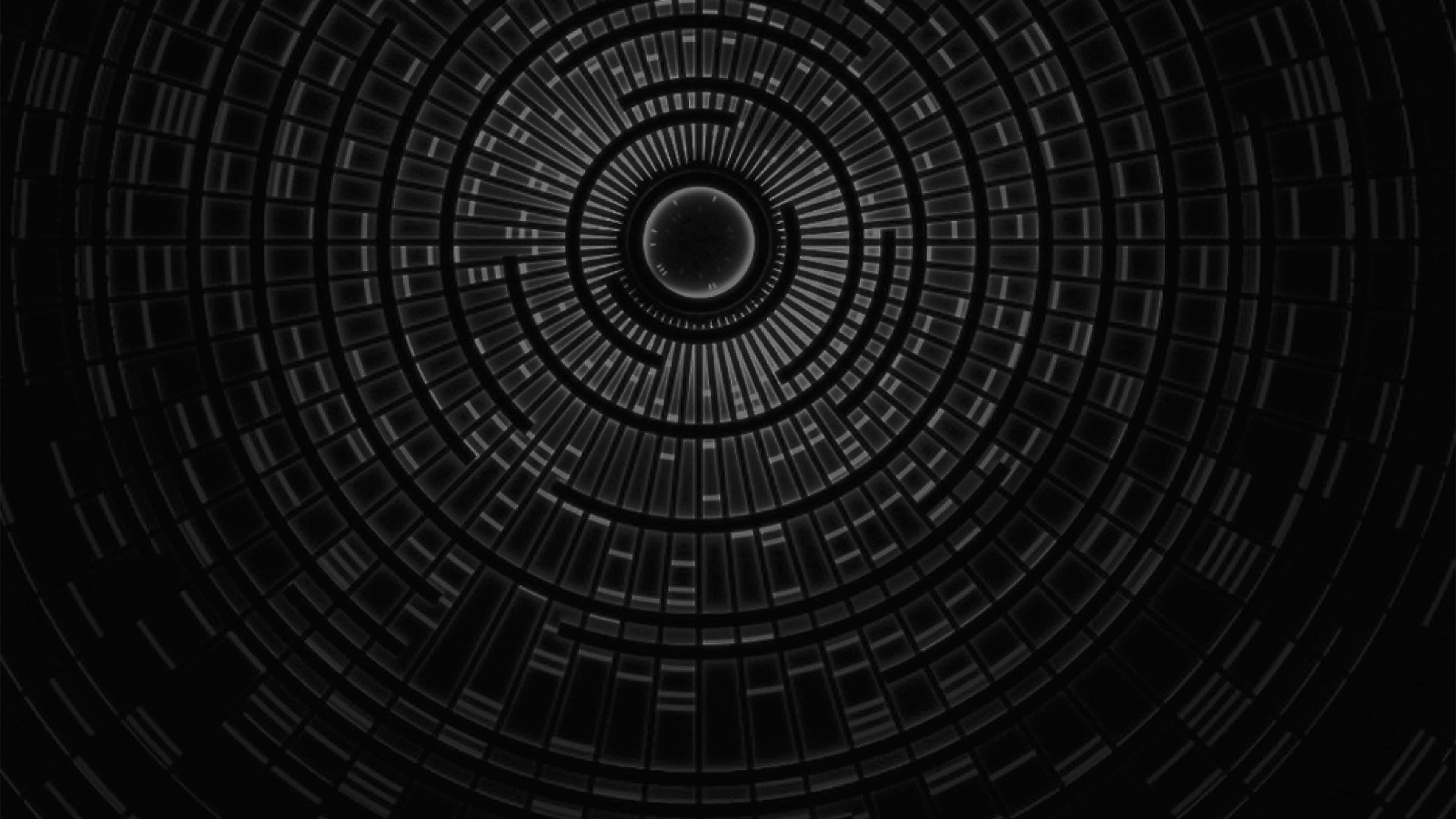 Dark Circles 桌布 壁紙 — 一個迷人的黑白抽象圖案，由同心圓和向內輻射的發光幾何片段組成。