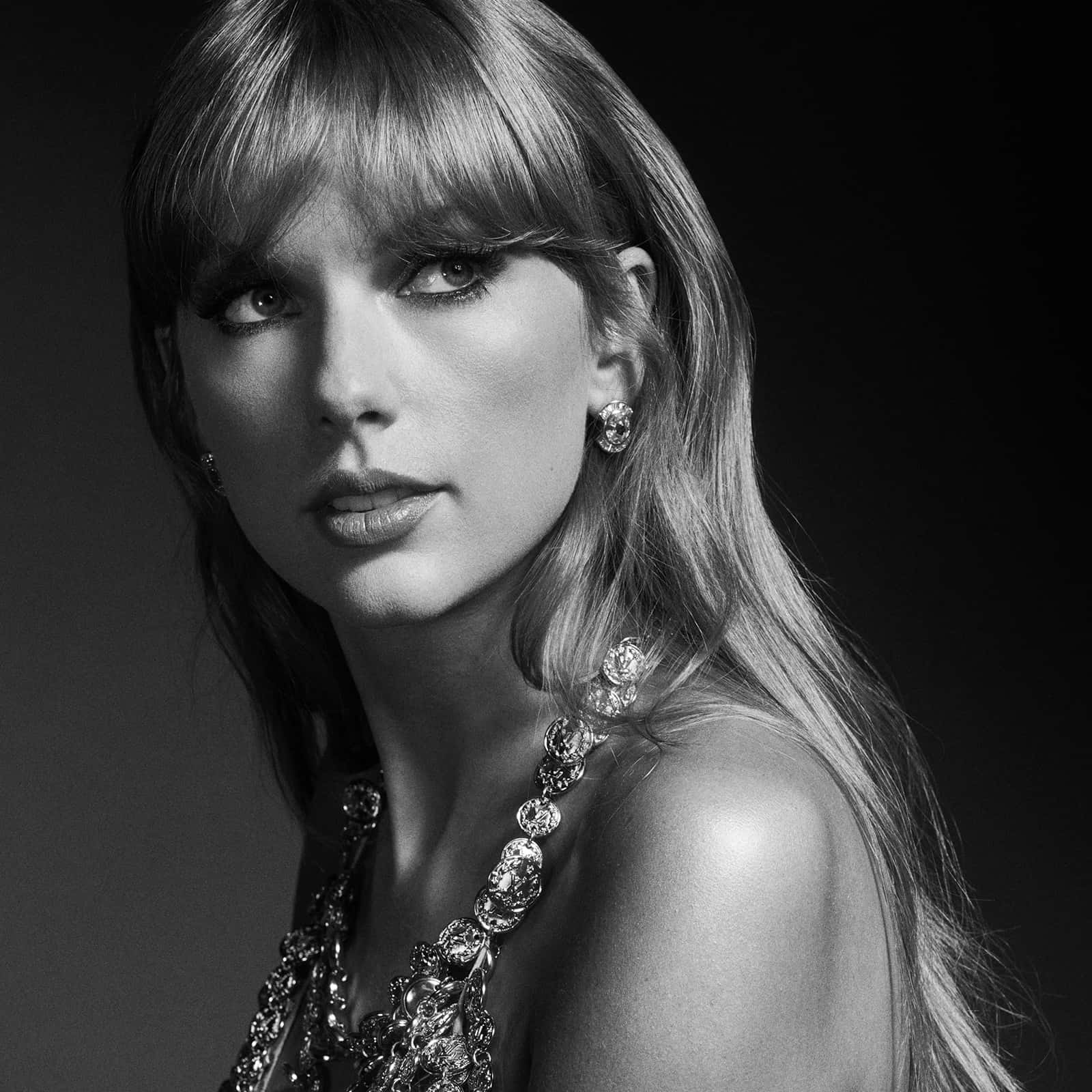 Black And White Celebrity 桌布 壁紙 — 一個迷人的黑白肖像，一個長頭髮的女人戴著閃爍的珠寶，背景是深色。