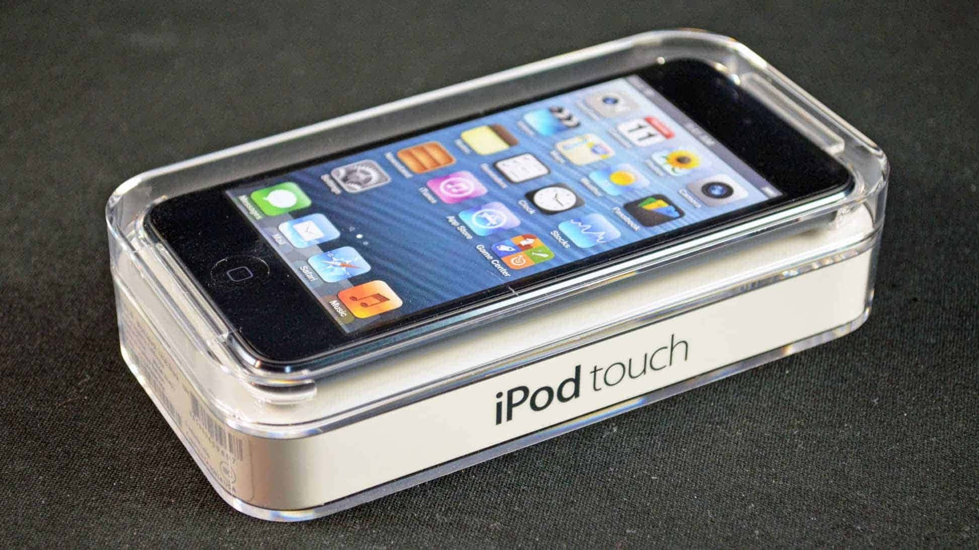 Music Player 桌布 壁紙 — 一個透明塑膠盒內裝有一台銀色 iPod touch，螢幕上色彩繽紛的應用程式圖示在深色布料背景前發光。