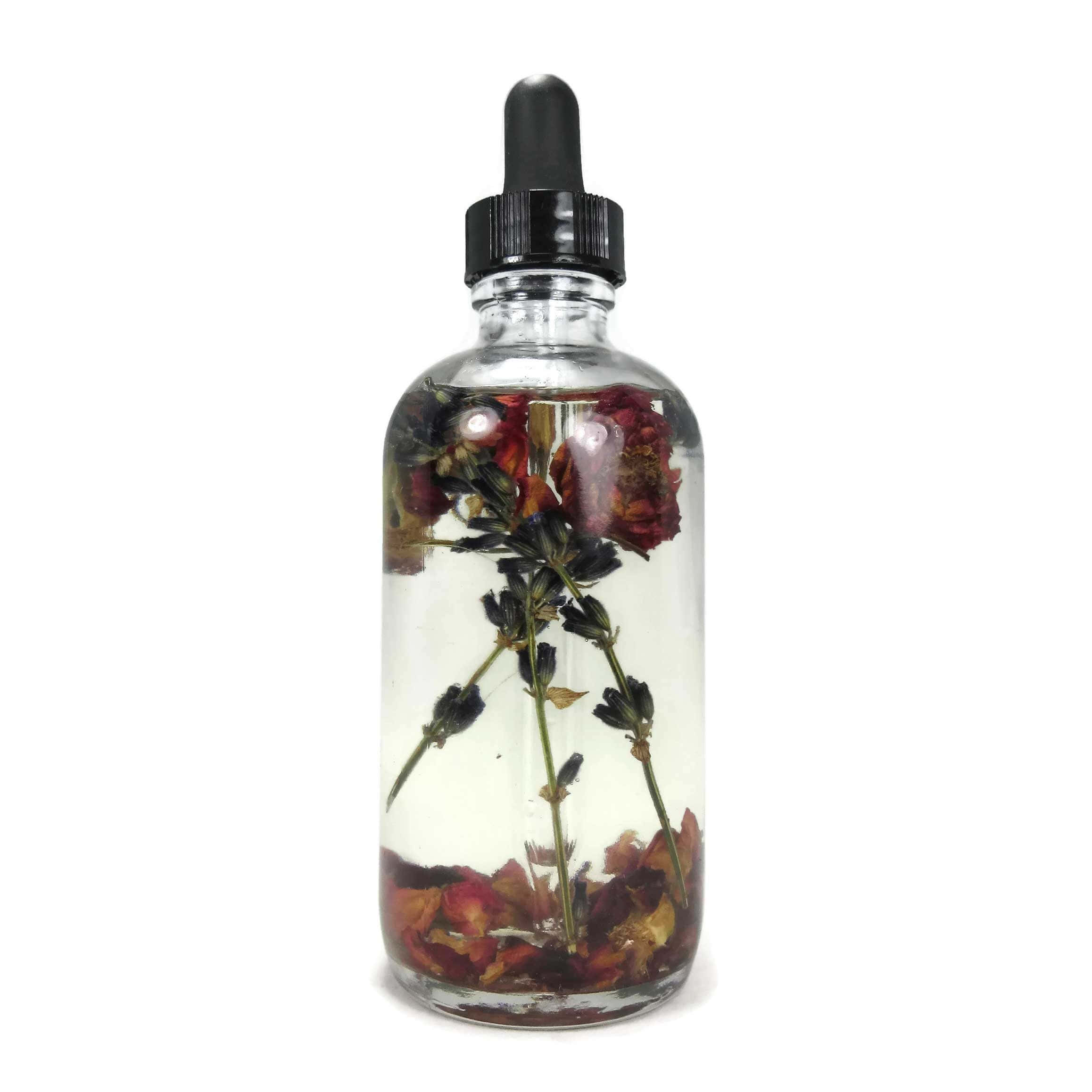 Rose Oil 桌布 壁紙 — 一個透明玻璃滴管瓶，裝滿水並浸泡著乾燥的紅玫瑰和薰衣草枝。