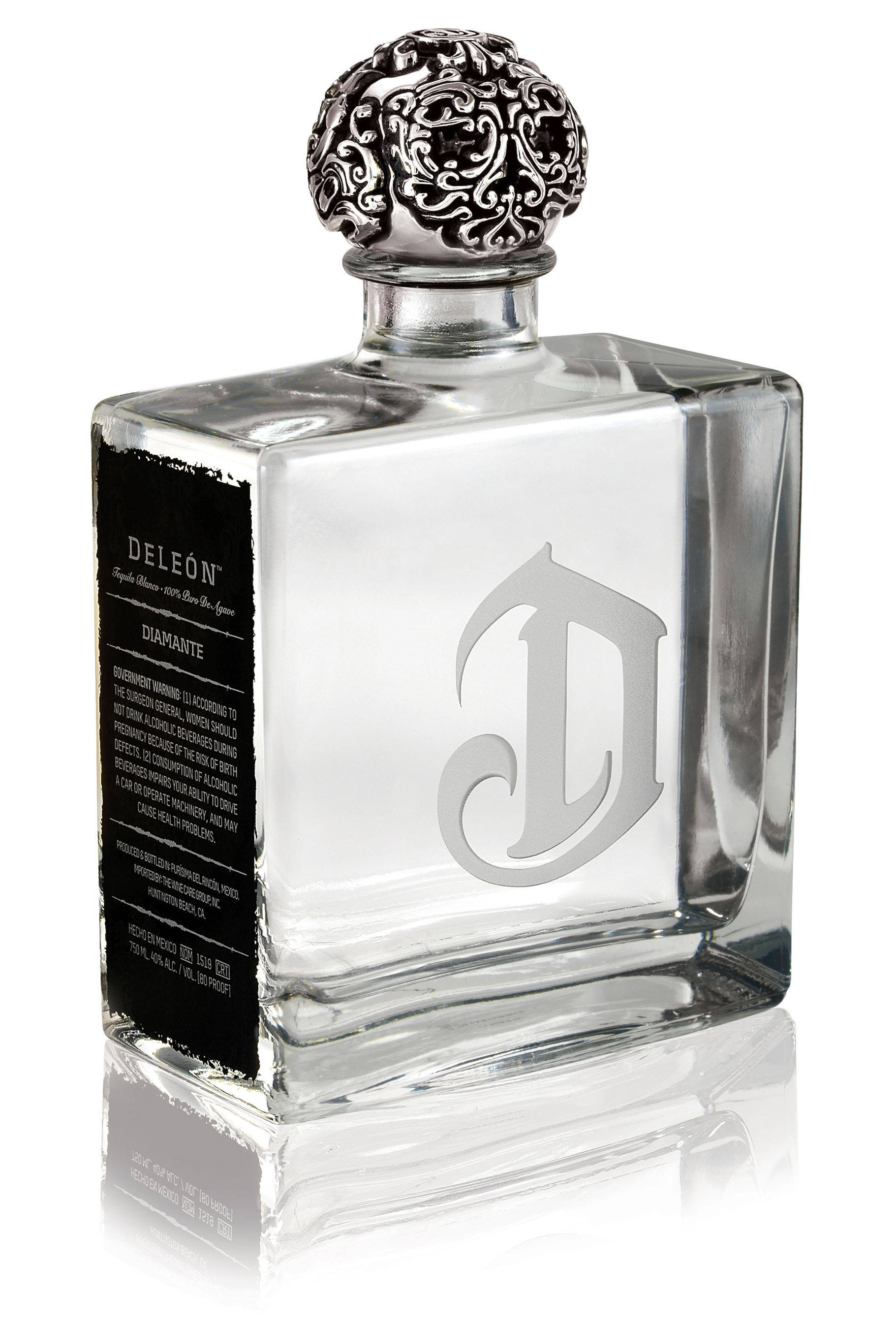 bottle 桌布 壁紙 — 一個透明玻璃瓶的DeLeón Diamante龍舌蘭酒，帶有華麗銀蓋和蝕刻標誌，在白色背景上獨立展示並有倒影。