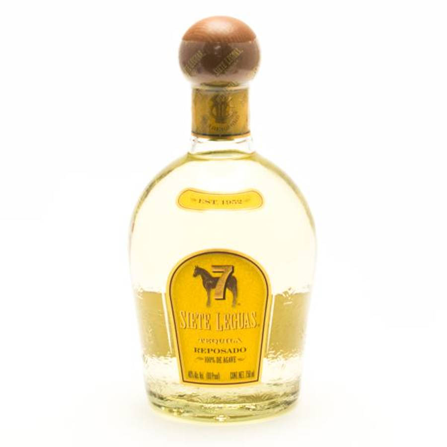 高清 桌布 壁紙 — 一個透明玻璃瓶的Siete Leguas reposado龍舌蘭酒，配有木塞和金色標籤，孤立地立在白色背景前。