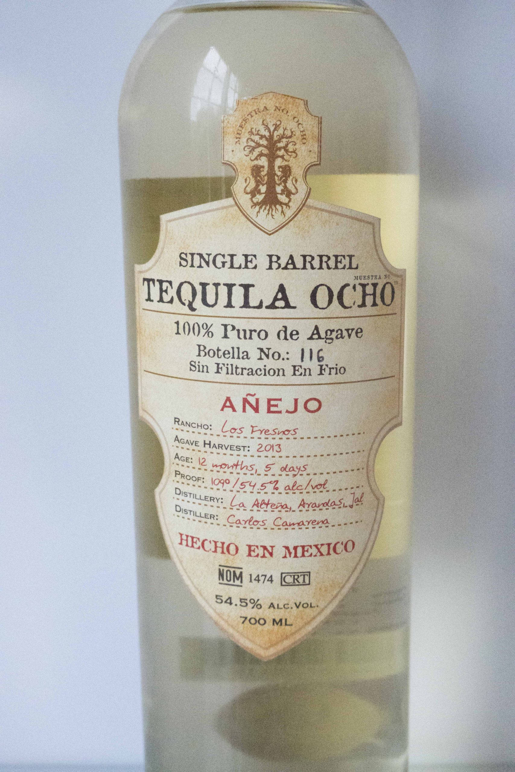 bottle 桌布 壁紙 — 一個透明玻璃瓶的Single Barrel Tequila Ocho Añejo，帶有詳細的復古風格標籤，顯示墨西哥龍舌蘭產地和54.5%酒精含量。