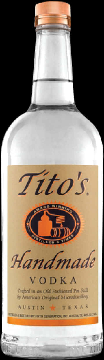 Titos Vodka Logo 桌布 壁紙 — 一個透明玻璃瓶的Tito's Handmade Vodka，帶有棕褐色標籤和銅色瓶蓋，立在黑色背景前。
