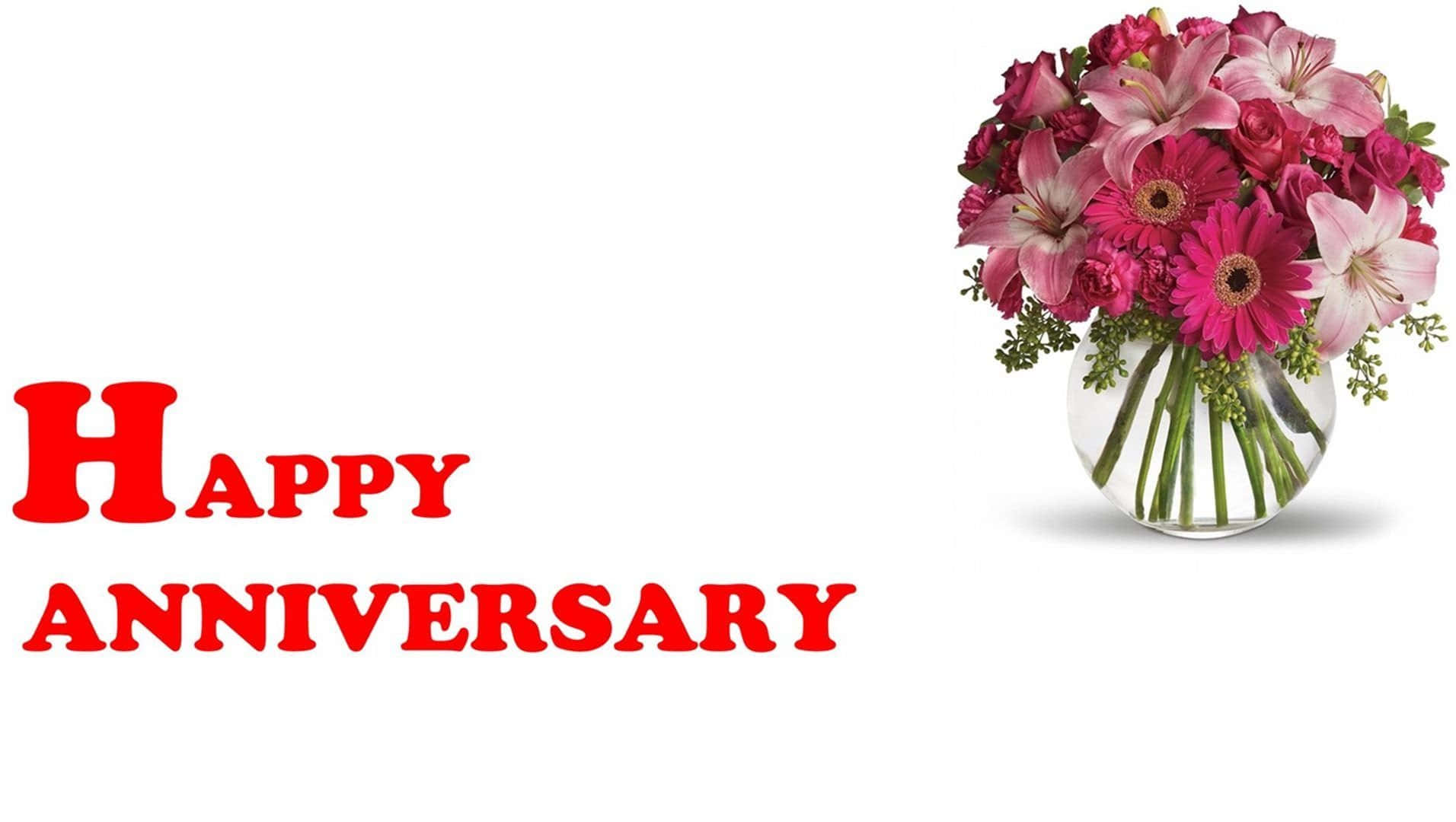Anniversary 桌布 壁紙 — 一個透明玻璃花瓶裡插著一束充滿活力的粉紅色和洋紅色花朵，旁邊是白色背景上大膽的紅色「Happy Anniversary」文字。
