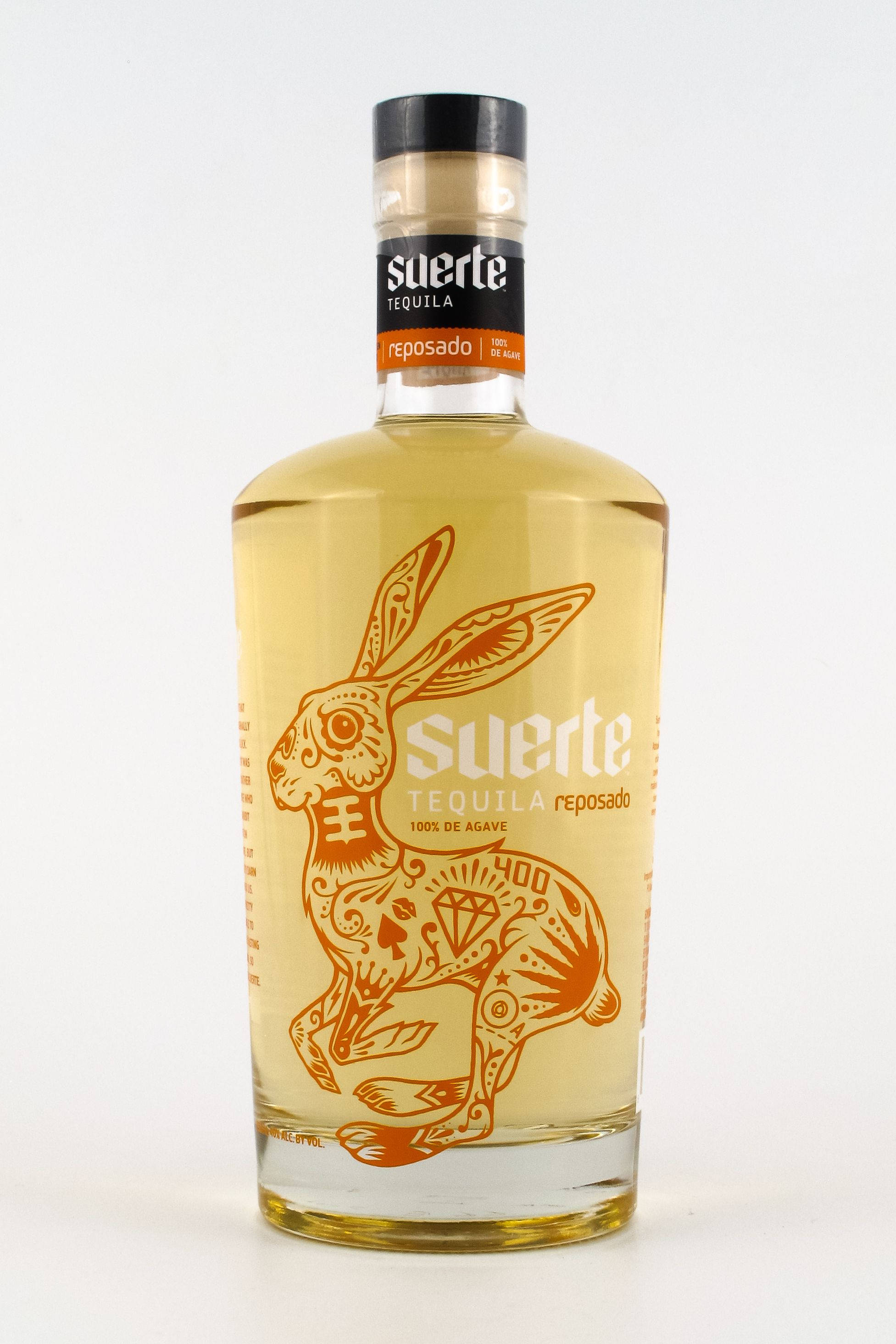 bottle 桌布 壁紙 — 一個透明的Suerte reposado龍舌蘭酒瓶，在純白色背景上呈現橙色糖骷髏兔子的設計。
