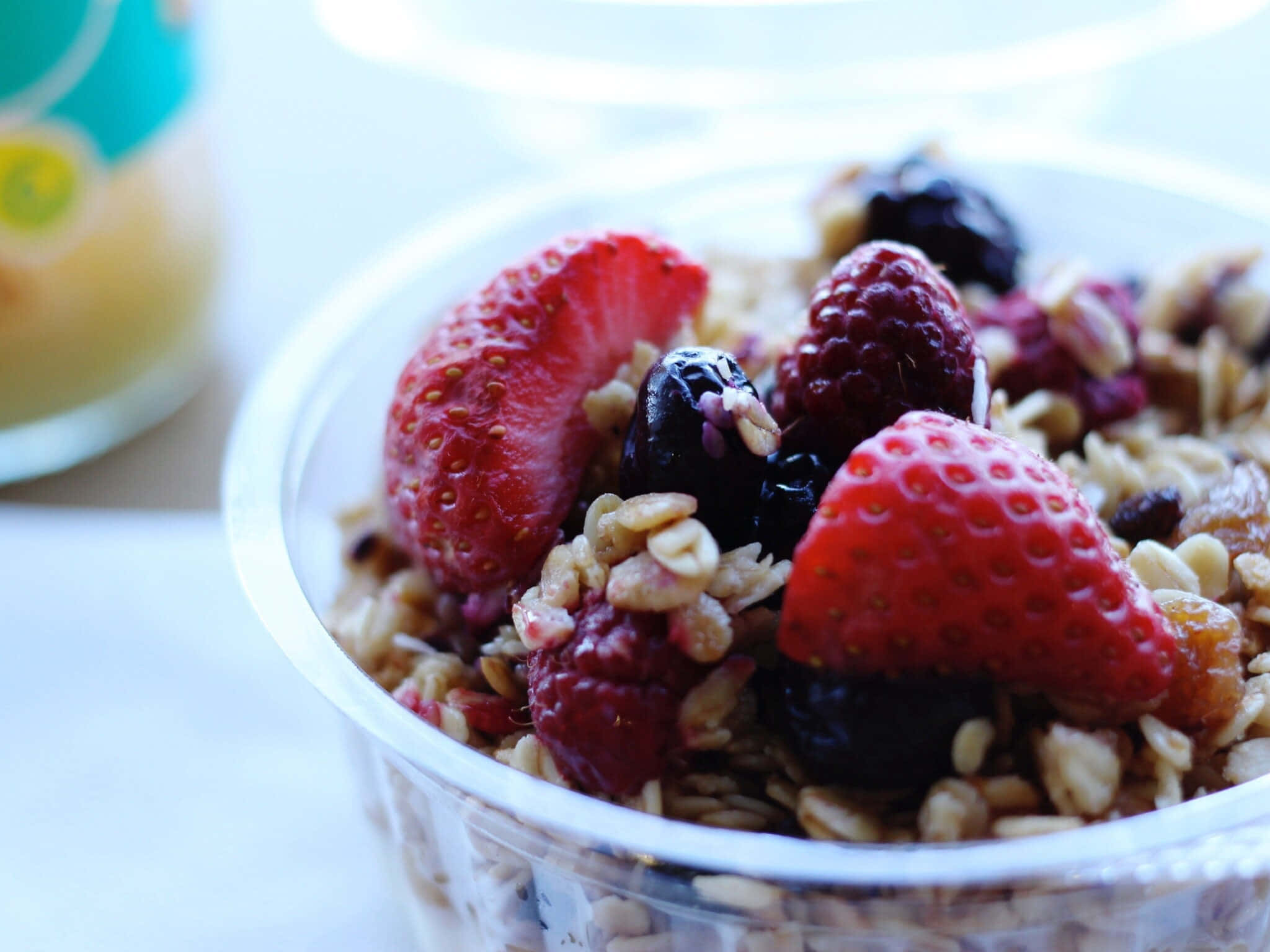 Healthy Food 桌布 壁紙 — 一個透明碗的特寫，裡面裝滿了格蘭諾拉麥片和新鮮草莓、覆盆子和藍莓。