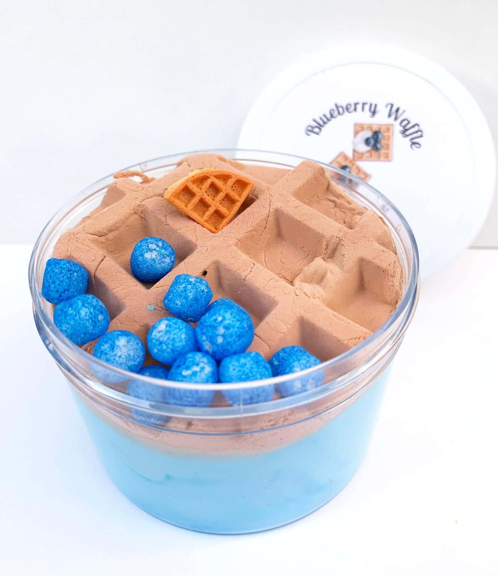 waffles 桌布 壁紙 — 一個透明罐子裝滿藍莓鬆餅主題的動力沙，內有藍色球體和鬆餅塊。
