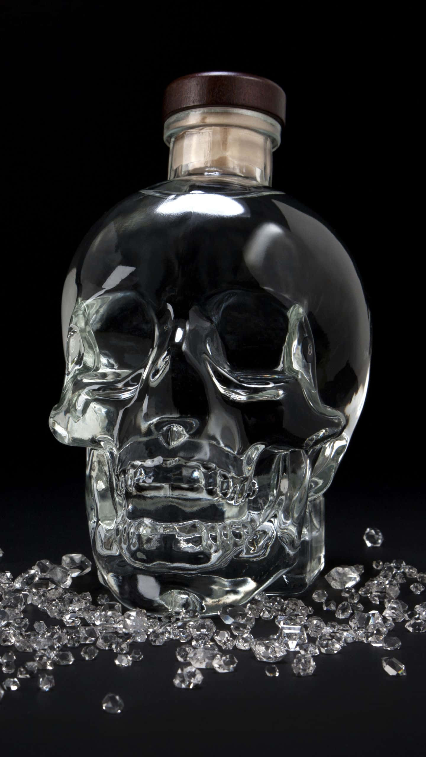 alcohol 桌布 壁紙 — 一個透明骷髏形玻璃瓶，帶有木蓋，放在黑色背景上閃閃發光的鑽石床上。