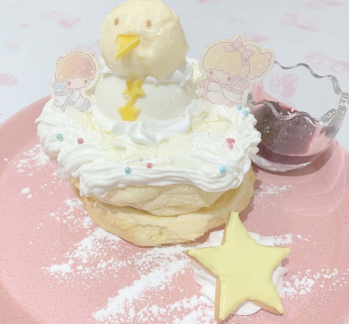 Kawaii Dessert 桌布 壁紙 — 一個造型奇特的蛋糕，形狀像巢中的小雞，用粉彩色裝飾和糖粉點綴，放在粉紅色盤子上。