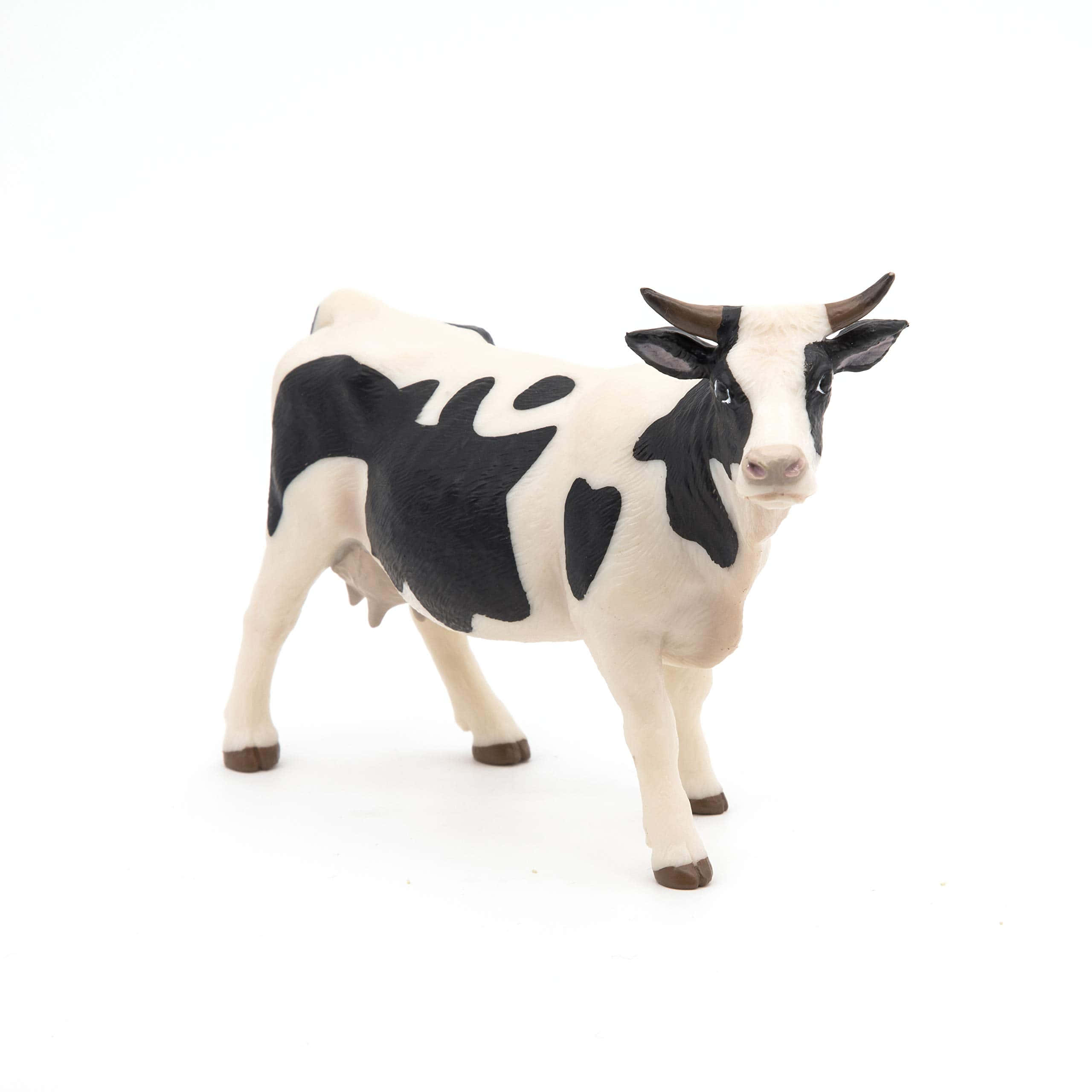 Black And White Cow 桌布 壁紙 — 一個逼真的黑白乳牛雕像在純白背景上警覺地站立。