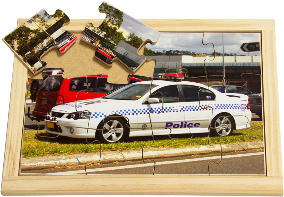 Police Car 桌布 壁紙 — 一個部分組裝的木框拼圖描繪了一輛白色警車停在草地路邊，背景有其他車輛和樹木。
