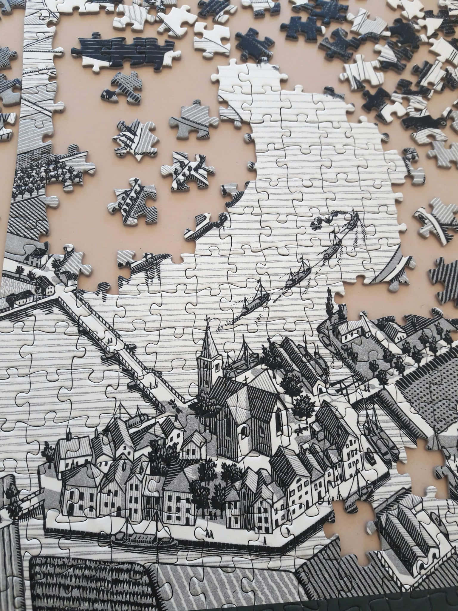 Puzzle 桌布 壁紙 — 一個部分組裝的黑白拼圖展示了一個詳細的復古歐洲村莊場景，有教堂和船隻。